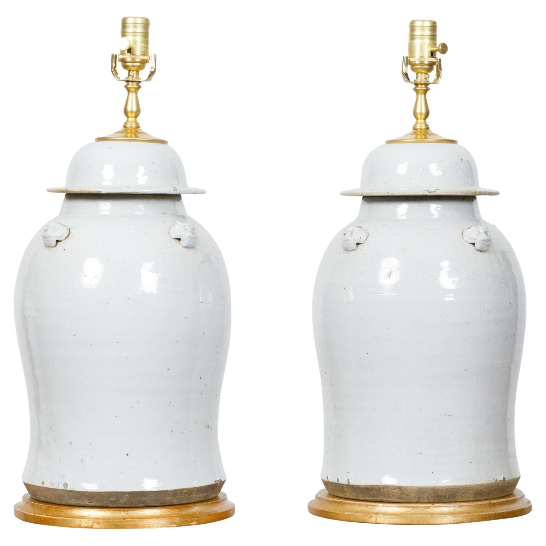 Pair of White Porcelain Lidded Urns Made into US-Wired Table Lamps on Gilt Bases For Sale