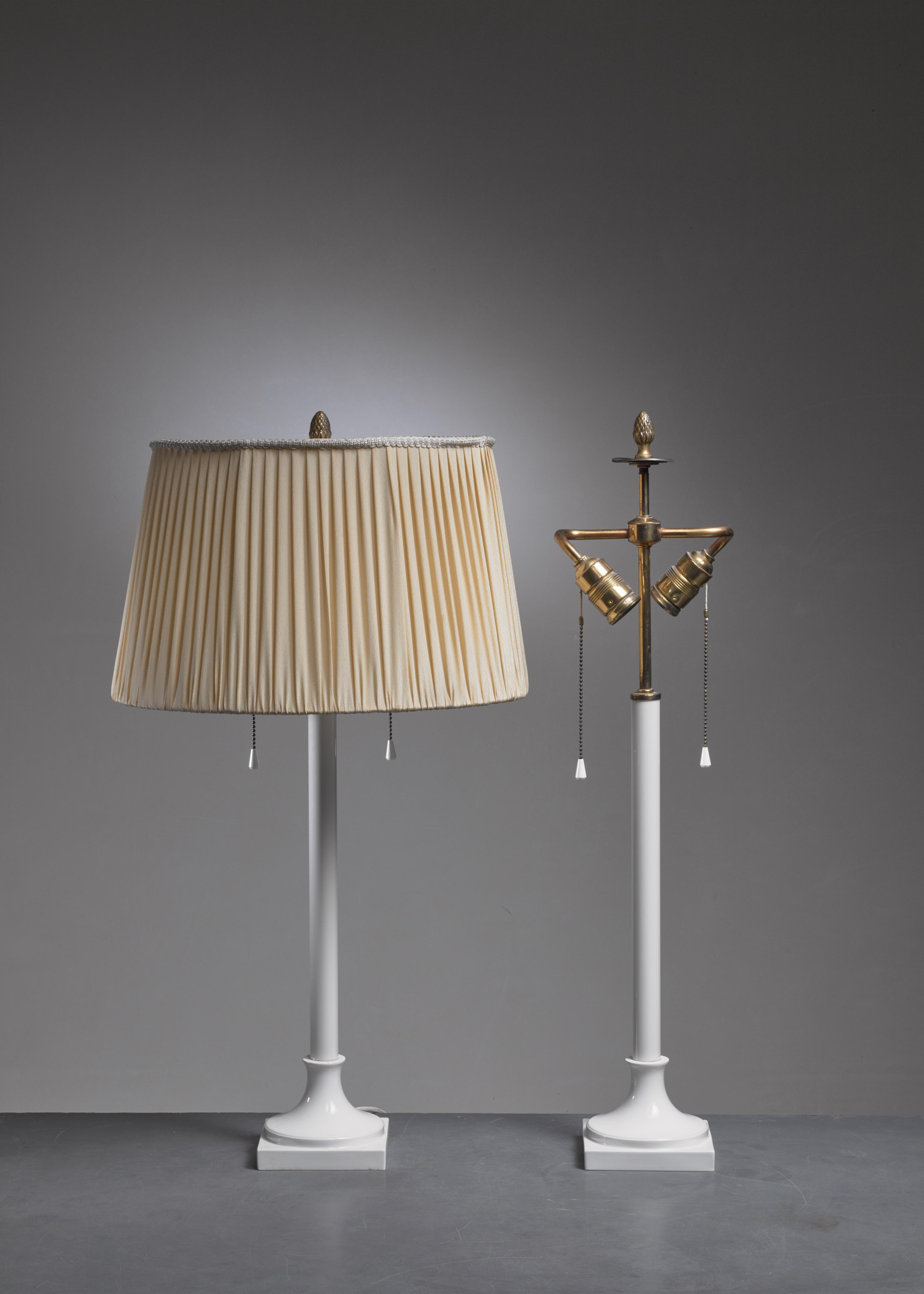 A pair of white porcelain table lamps, designed by Alice von Pechmann for KPM Berlin. The lamp has two fittings and a brass pinecone decoration on top.

The measurements, price and shipment costs stated are of the bases without a shade.
