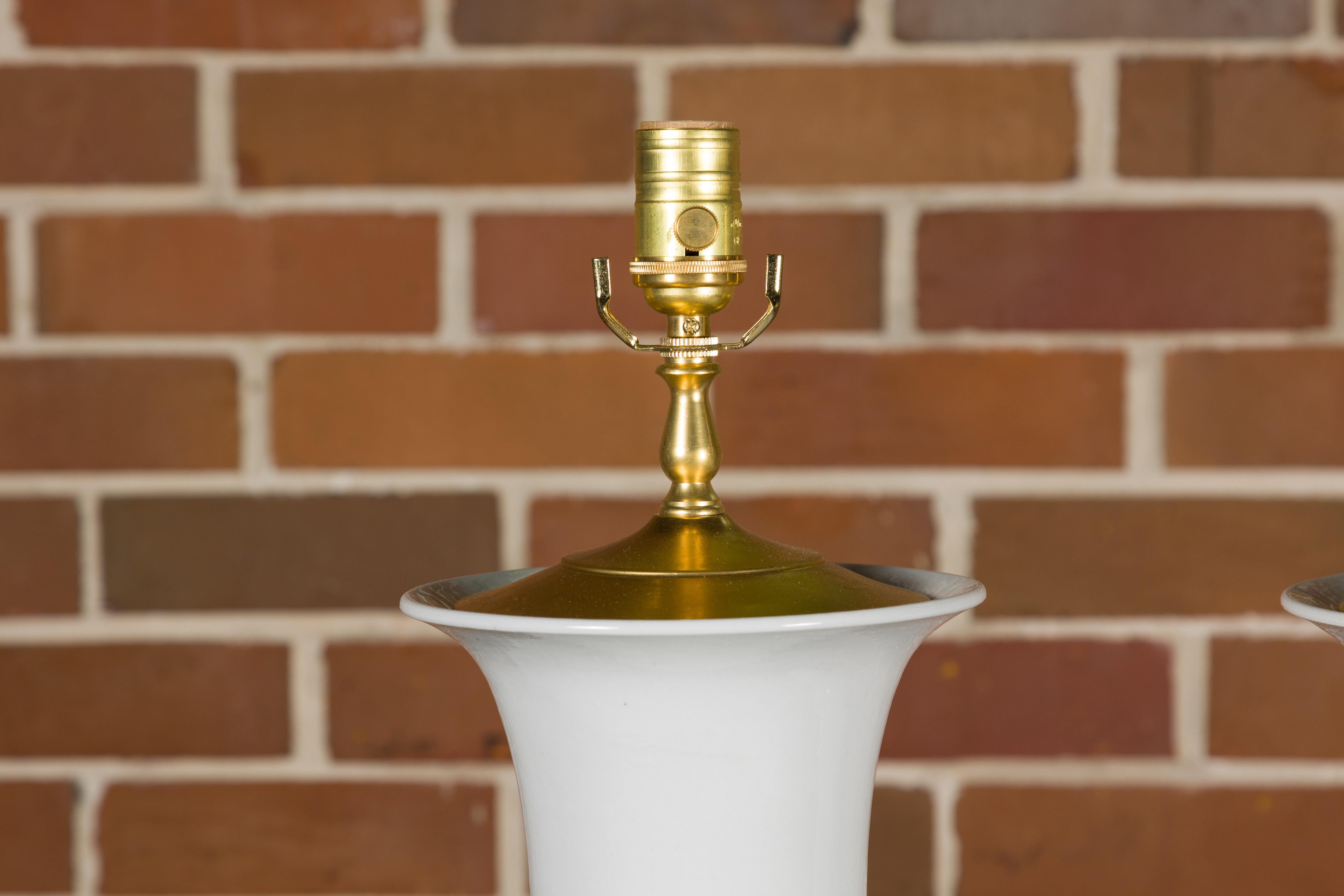 A pair of white porcelain table lamps on custom lucite bases, professionally rewired for the USA. This elegant pair of white porcelain table lamps, gracefully poised on custom lucite bases, embodies a serene and timeless beauty, making them a