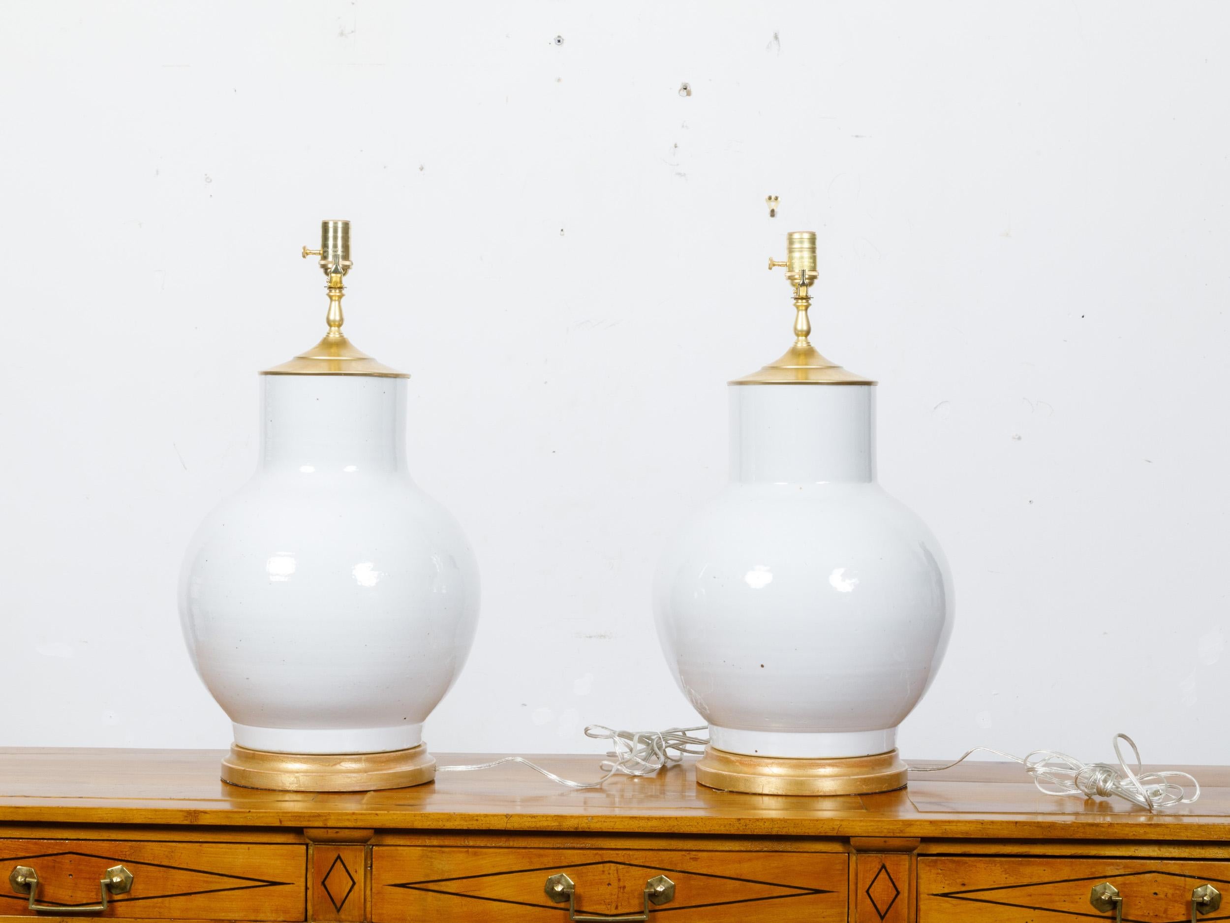 20th Century Pair of White Porcelain Vases Made into US-Wired Table Lamps on Giltwood Bases For Sale