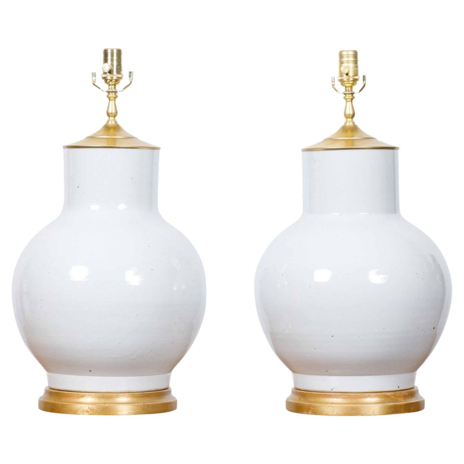 Paire de vases en porcelaine blanche transformés en lampes de table câblées aux États-Unis sur bases en bois doré