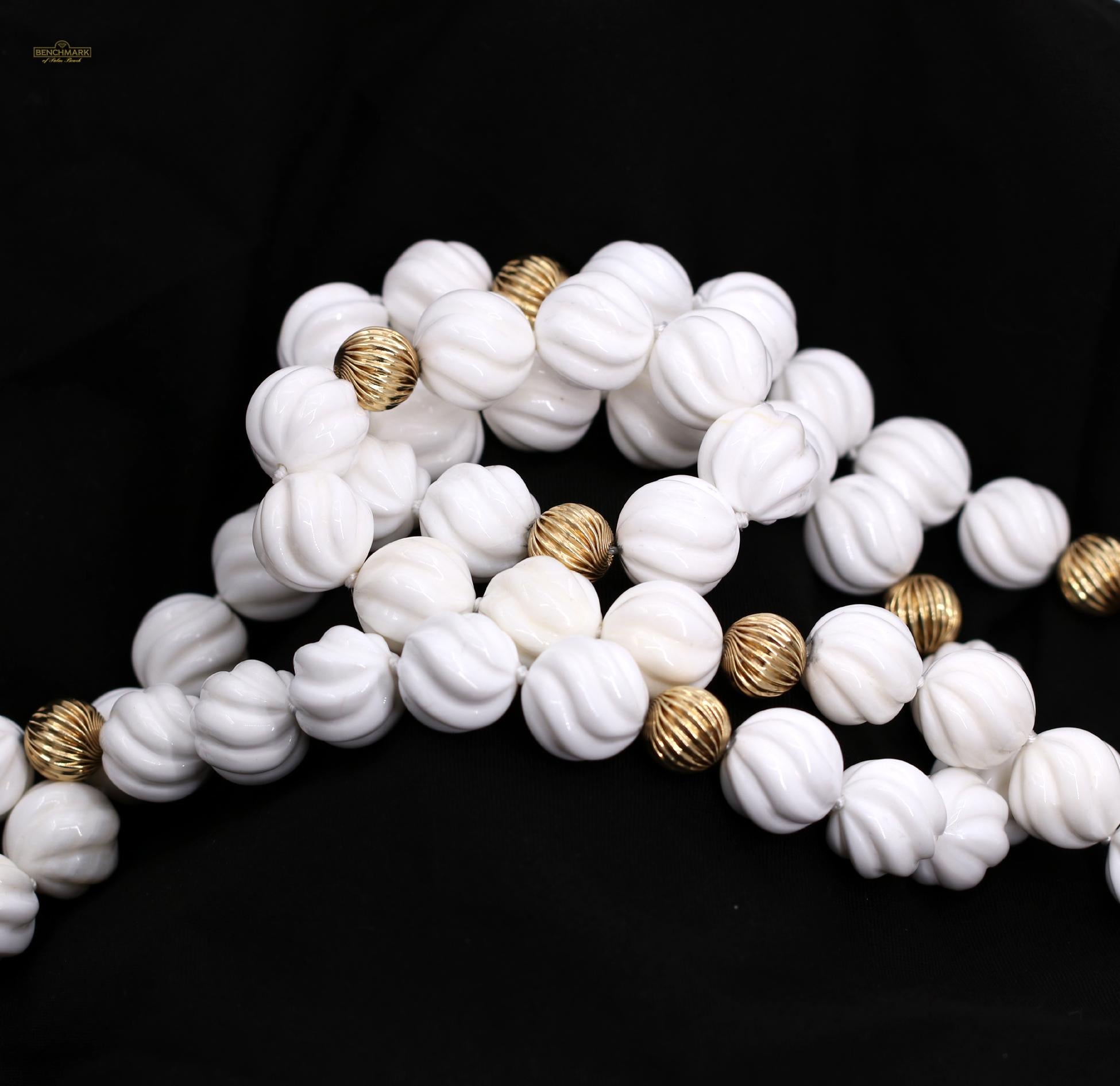A set of necklaces, comprised of a pattern of 5 white spiral design shell beads, and a fluted 14K yellow gold bead. With one necklace measuring 18 1/2 inches, and the other measuring 22 inches, there are a variety of ways with which it can be worn.