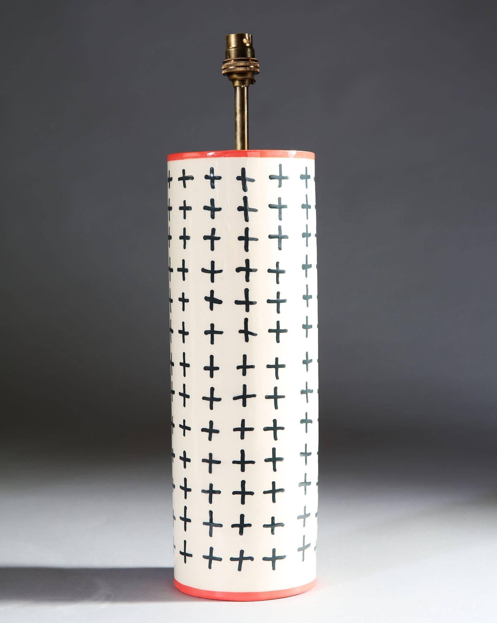A pair of cylindrical studio pottery vases with a white glaze and black geometric motif, with contrasting pink rims, now converted as lamps.