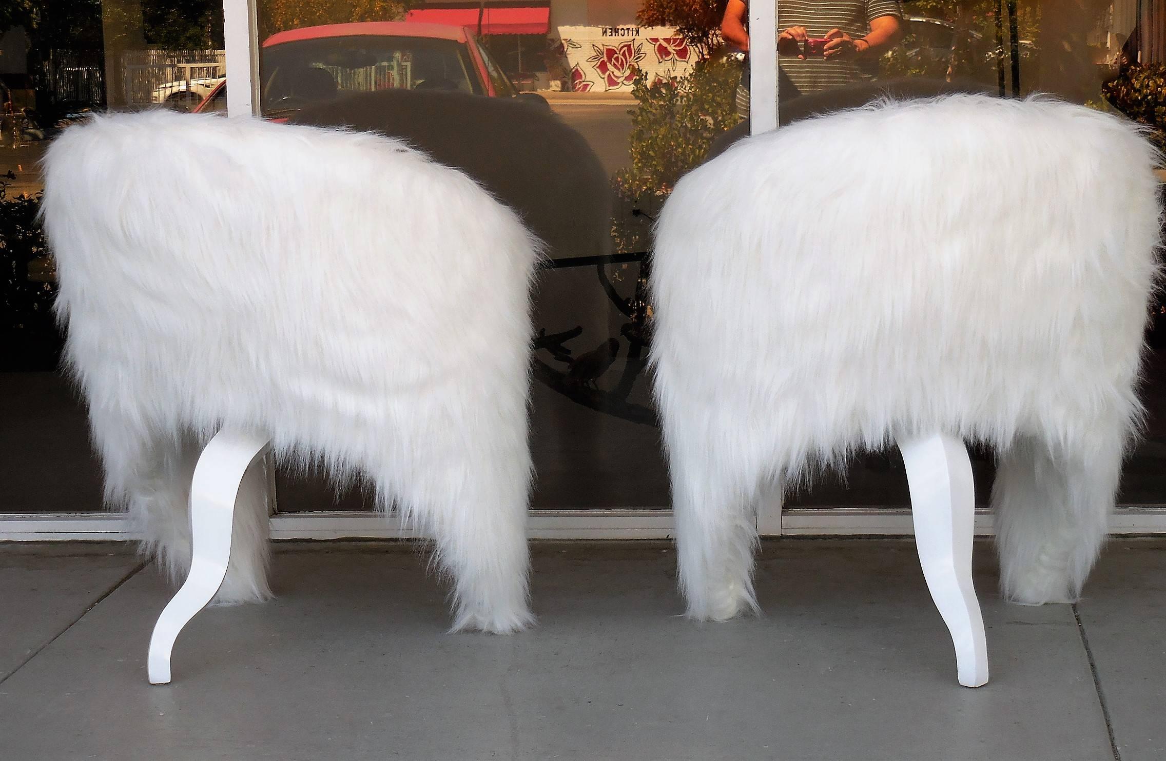 A pair of surreal lounge chairs. The back envelopes the seat and become the front legs. The shape is balanced by a wood tail like third leg.