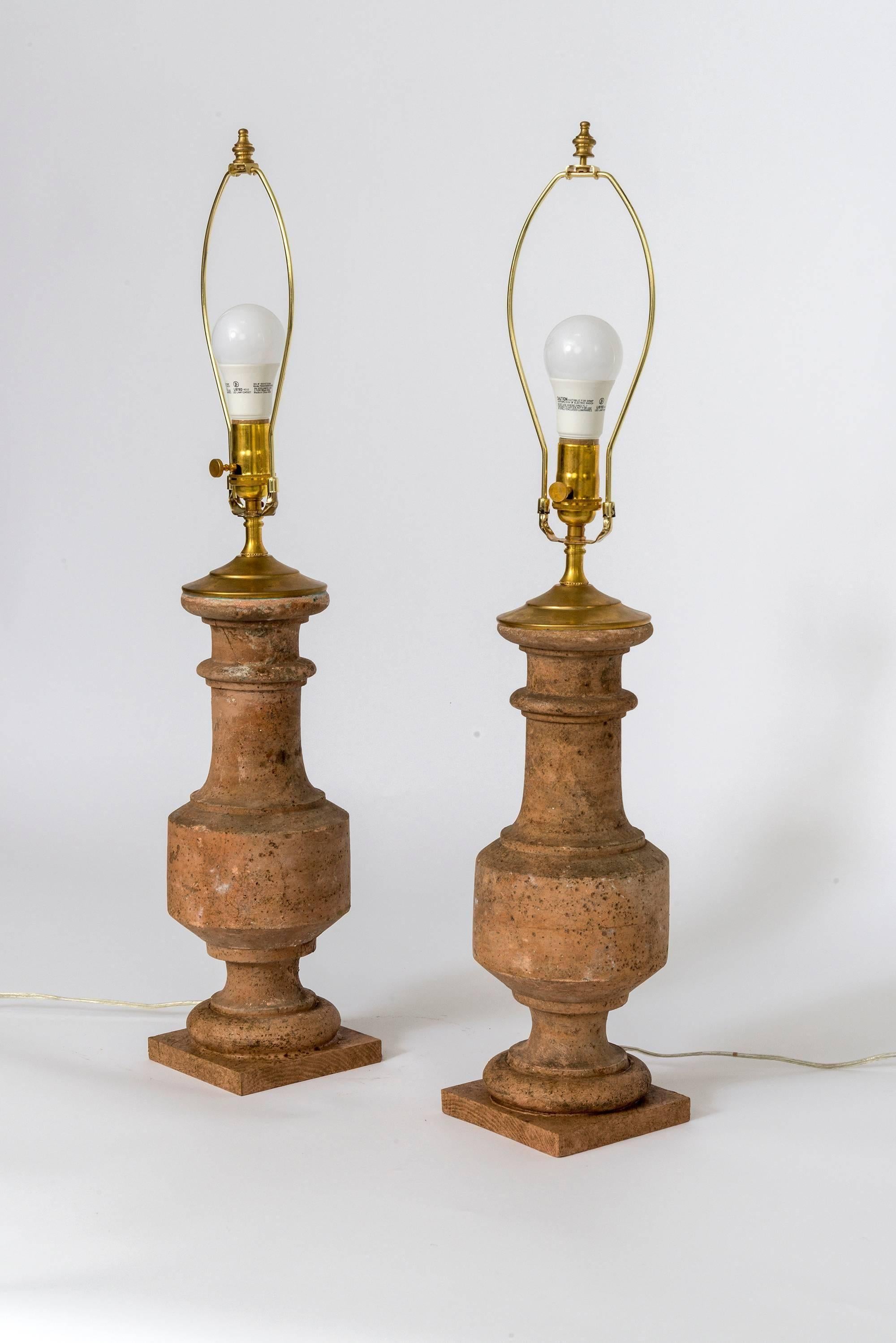 A very nice pair of white/grey handcrafted toned terracotta baluster table lamps, re wired to USA specification having brass tops.