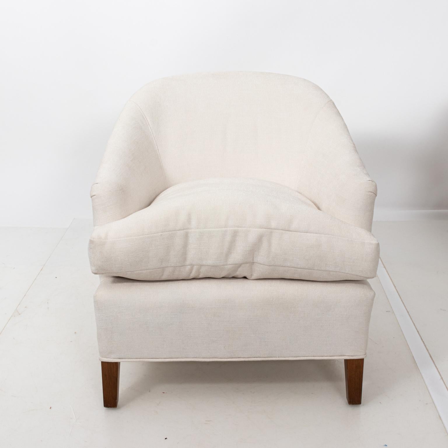 Pair of white upholstered armchairs freshly upholstered with new down feather cushions, circa 1950s. Please note of wear consistent with age including minor finish loss to the wood legs. Made in the United States.
