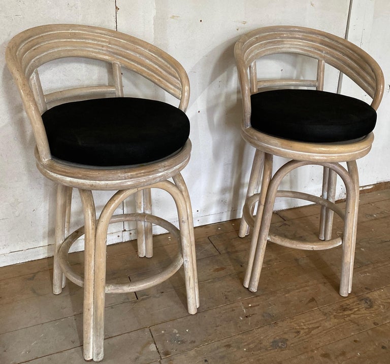 Pair of white washed faux bamboo bentwood bar stools or counter stools. The stools have black cushions. Great proportions for comfort and style. The rounded barrel back gives great support. Use it in a modern, casual or classical setting.
Depending