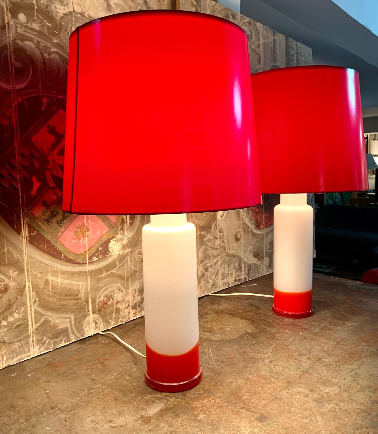 Pair of Swedish modern qpaque white and red glass table lamps, The lamps combine the color white and red in the central column and the lampshades are made of red plexiglass. Rewired for USA.