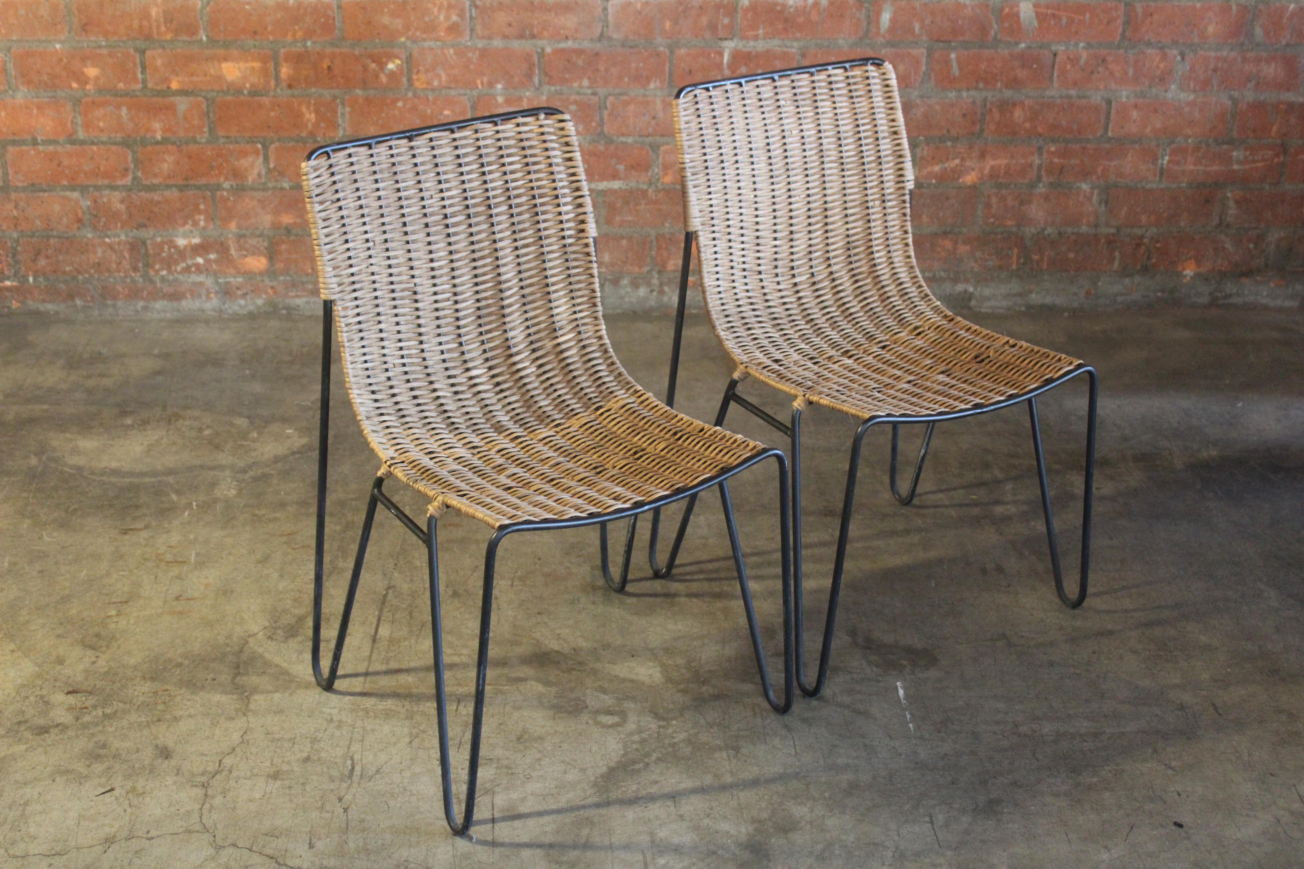 Pair of iron side chairs in wicker. Newly hand woven with new wicker. Sold as a pair.