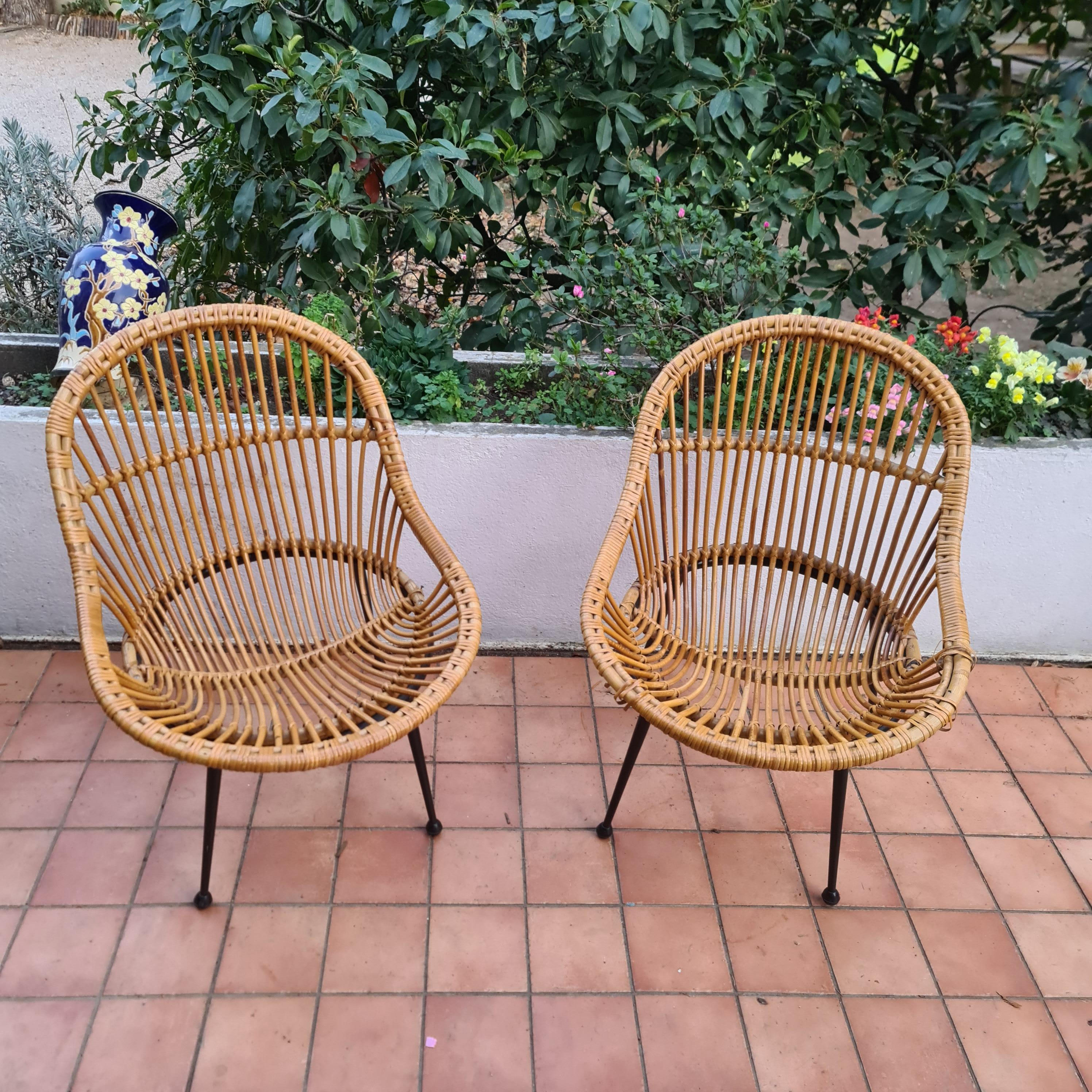 Pretty pair of basket armchairs in wicker and black steel base circa 1960, some lacks on one of the armchairs, state of wear consistent with age,  design and comfortable, tubular structure in black lacquered metal .Mid century modern