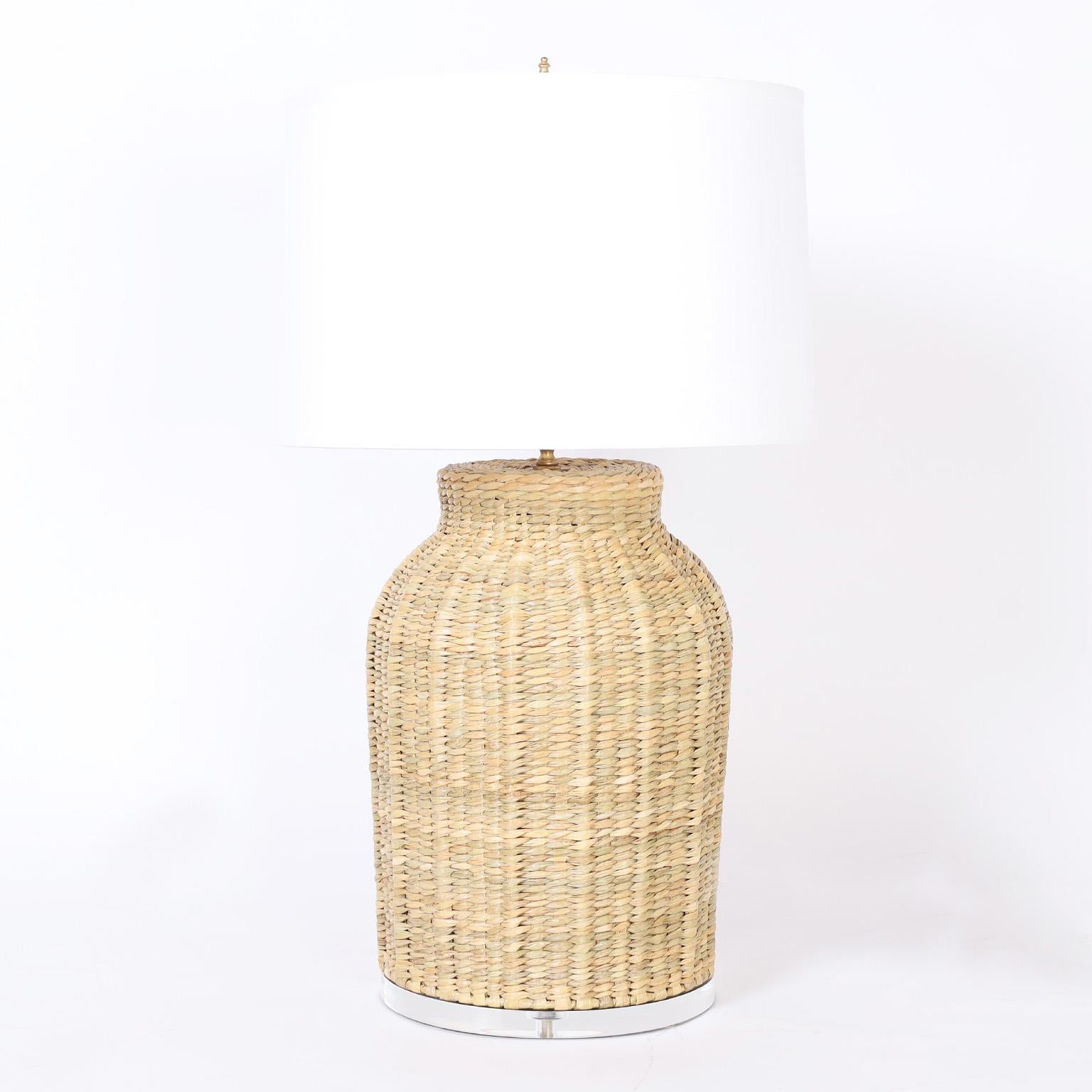 Asian modern style table lamps hand crafted in wicker or reed in a classic bottle form, in a bold scale, presented on lucite bases, from the FS Flores Collection designed and offered exclusively by F.S. Henemader Antiques.