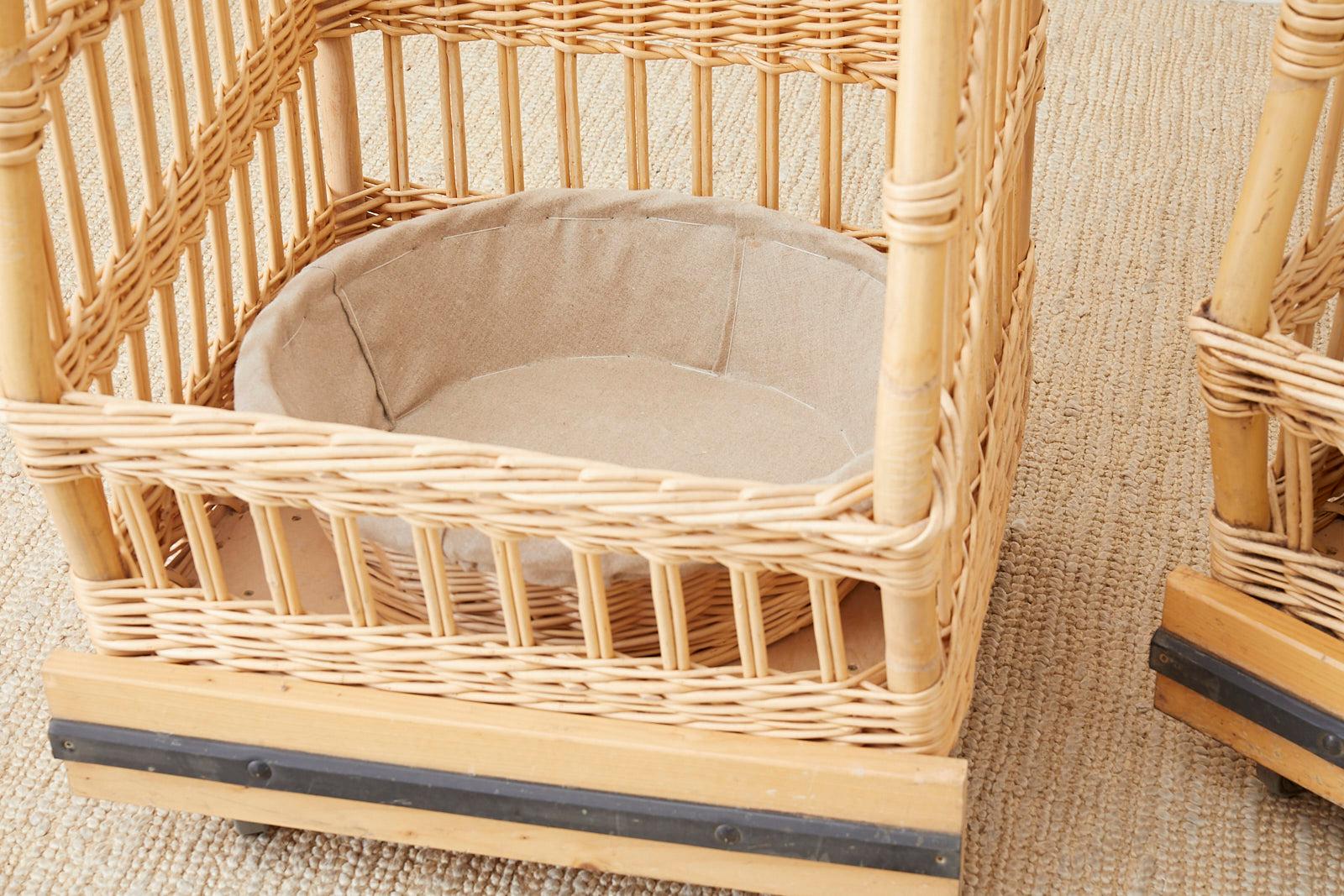 Rolling pair or boulangerie bread display bins or baskets featuring woven wicker over a rattan frame. The bins have a square form with three sides and an open front and top. They are mounted on wood with small casters. Each bin has a round removable