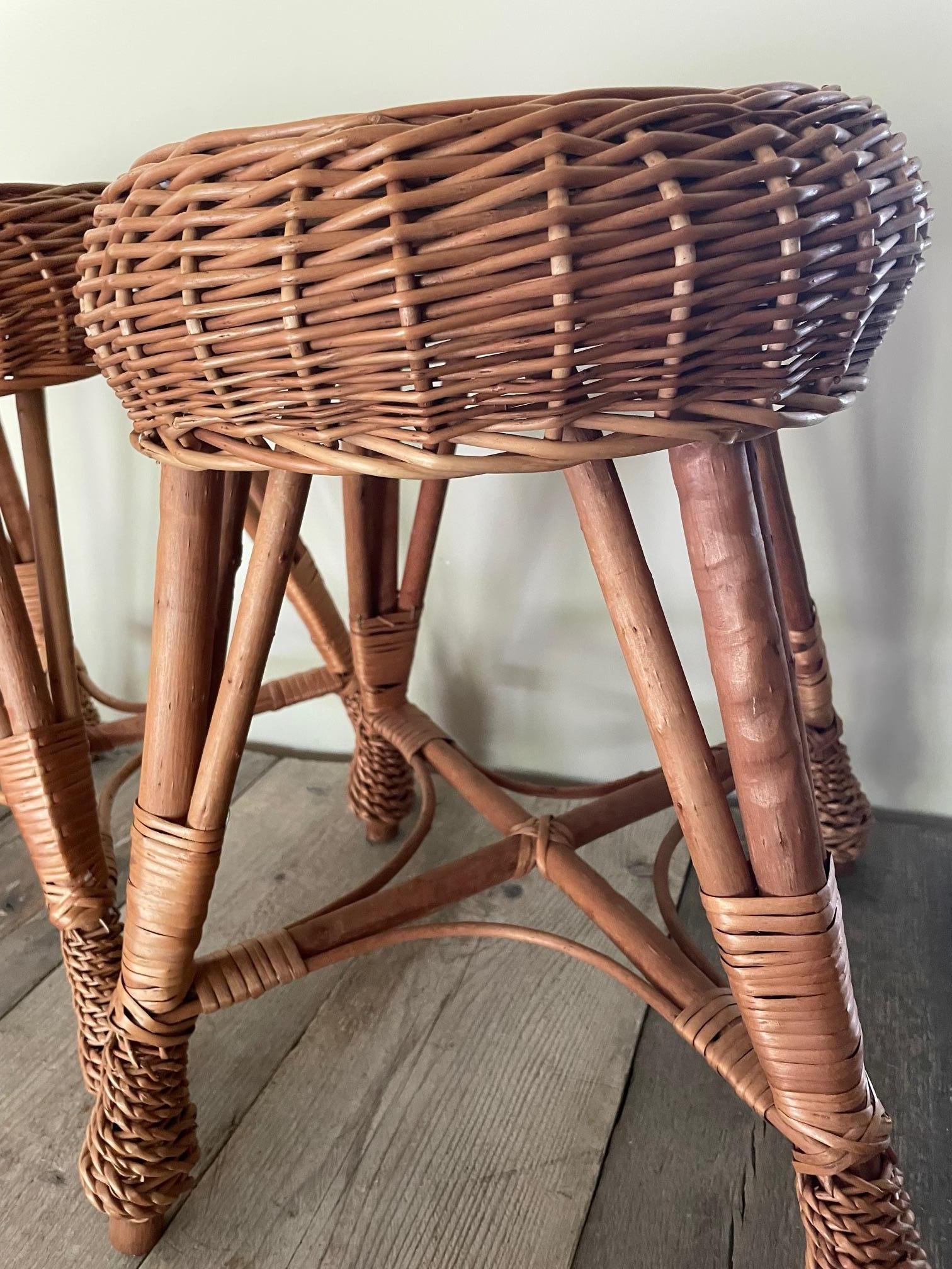 A pair of wicker stools, re-edited from a 1960s Italian model. They are very fashionable at the moment and are of a very high standard of finish, with turned legs.