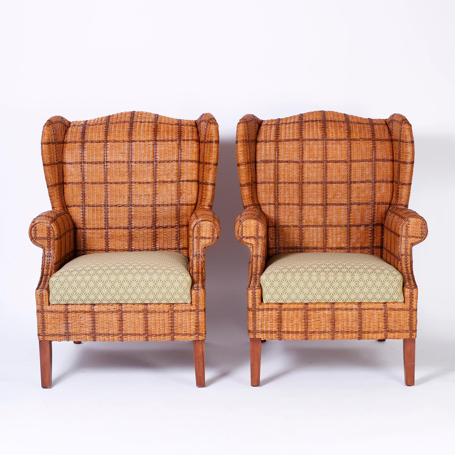 Pair of wicker armchairs with a classic wingback form and featuring a two-tone faux plaid upholstery, inviting stance, and tapered legs.