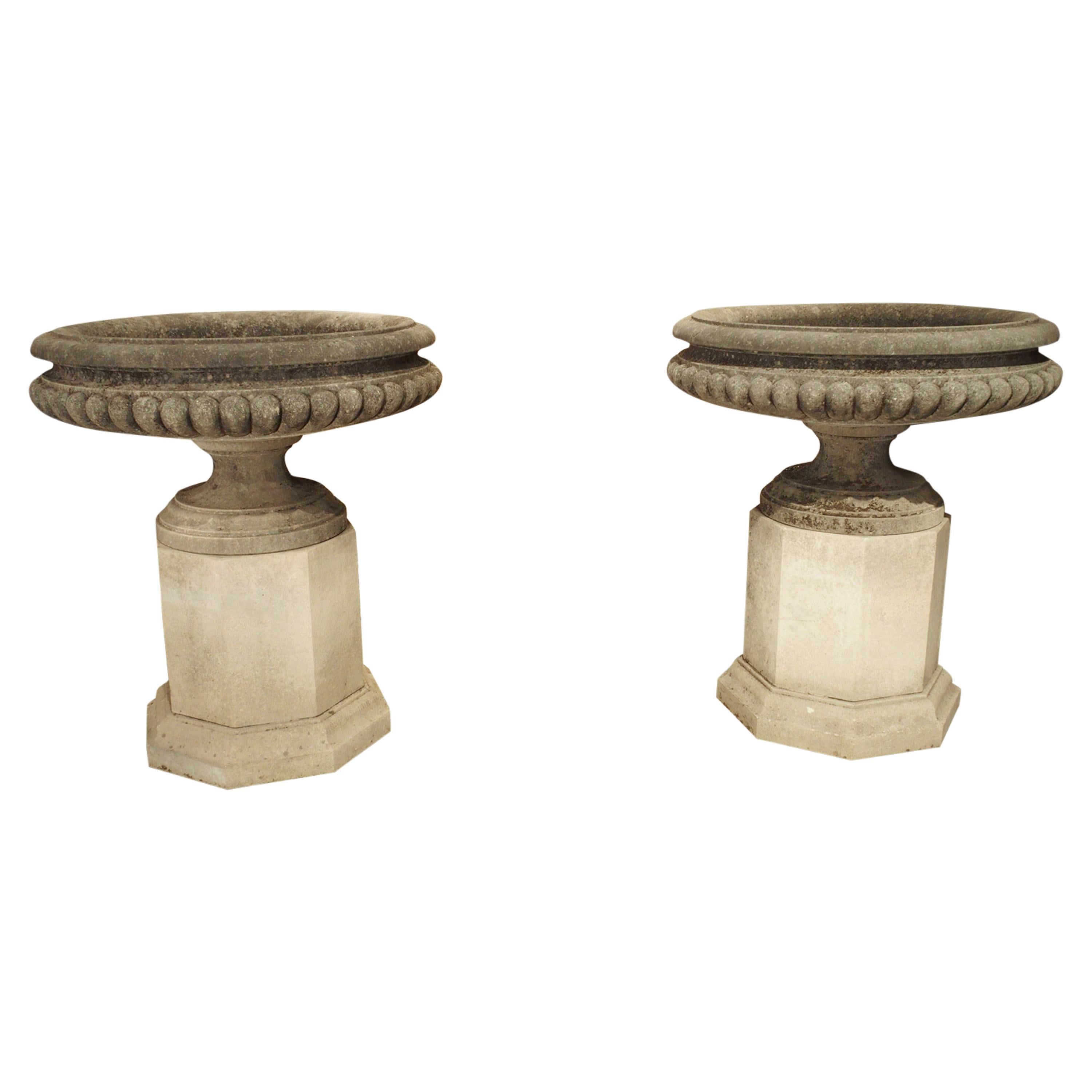 Pair of Wide Lobed Stone Urns on Octagonal Plinths