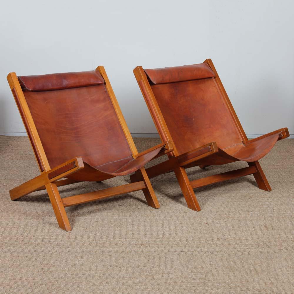 This pair of wide wood and leather armchairs dates from the 1980s. They are in good vintage condition. The leather has a nice patina.