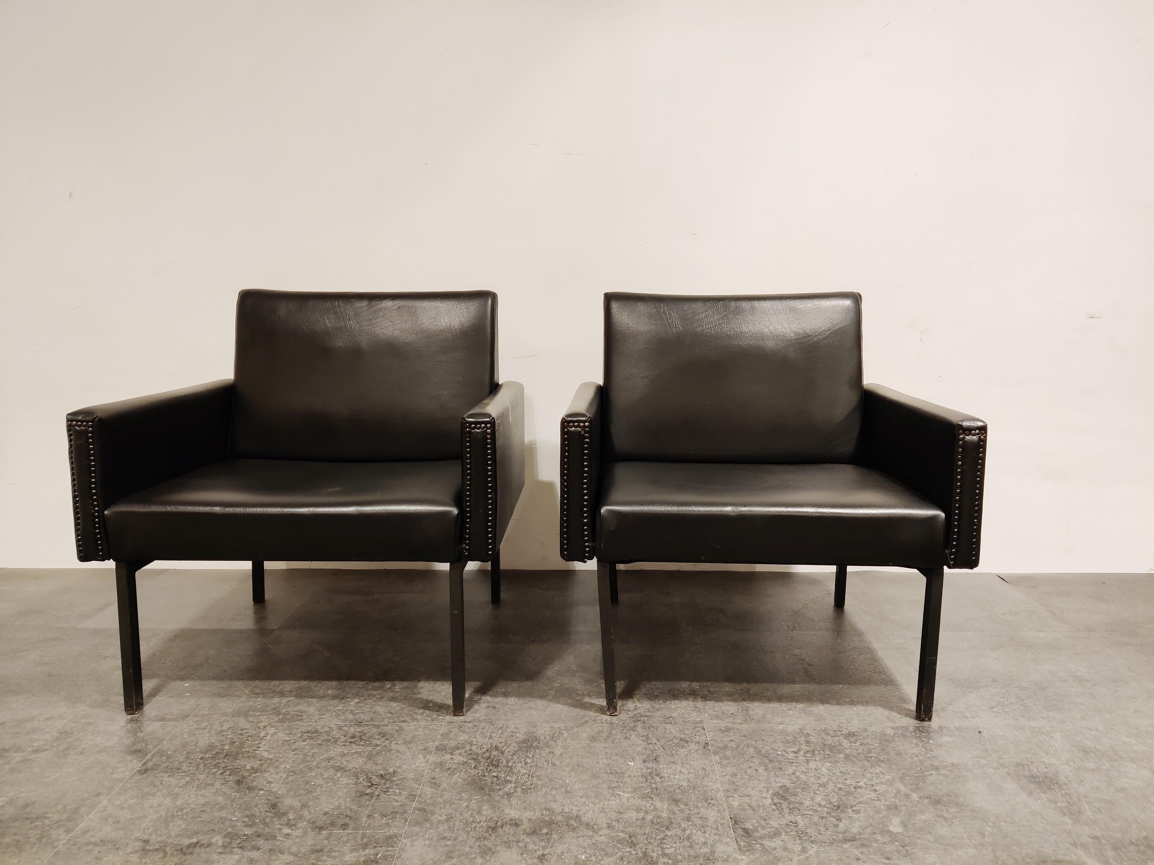 Pair of midcentury armchairs by Wilkhan from the 1960s.

Black steel legs and original black leatherette upholstery with buttoned front.

The chairs are in overall good condition with normal age related wear.

Height: 77cm/27.55
Seat height: