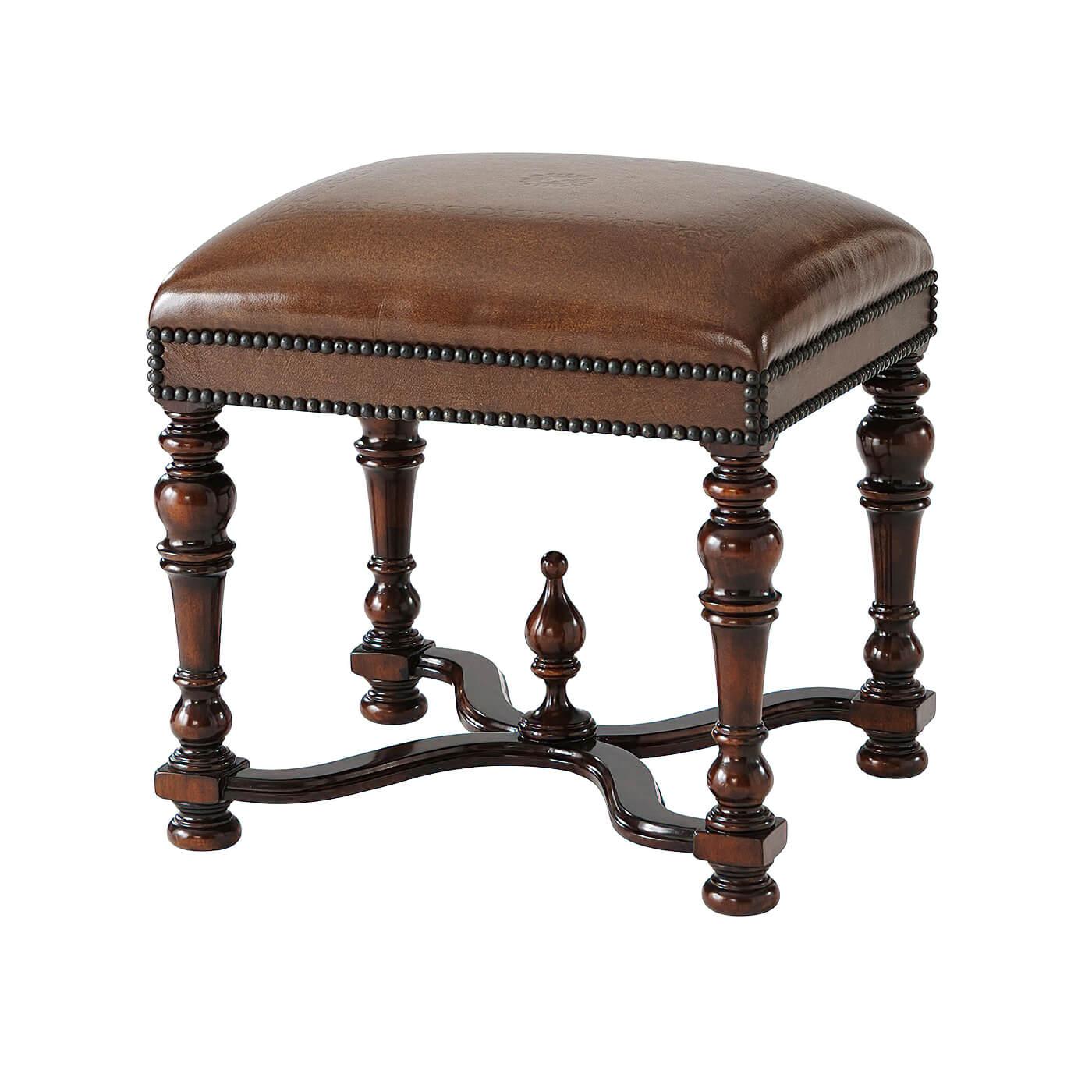 A William and Mary style hand carved stool with a tooled leather upholstered seat, studded decoration, on turned legs, and wavy 
