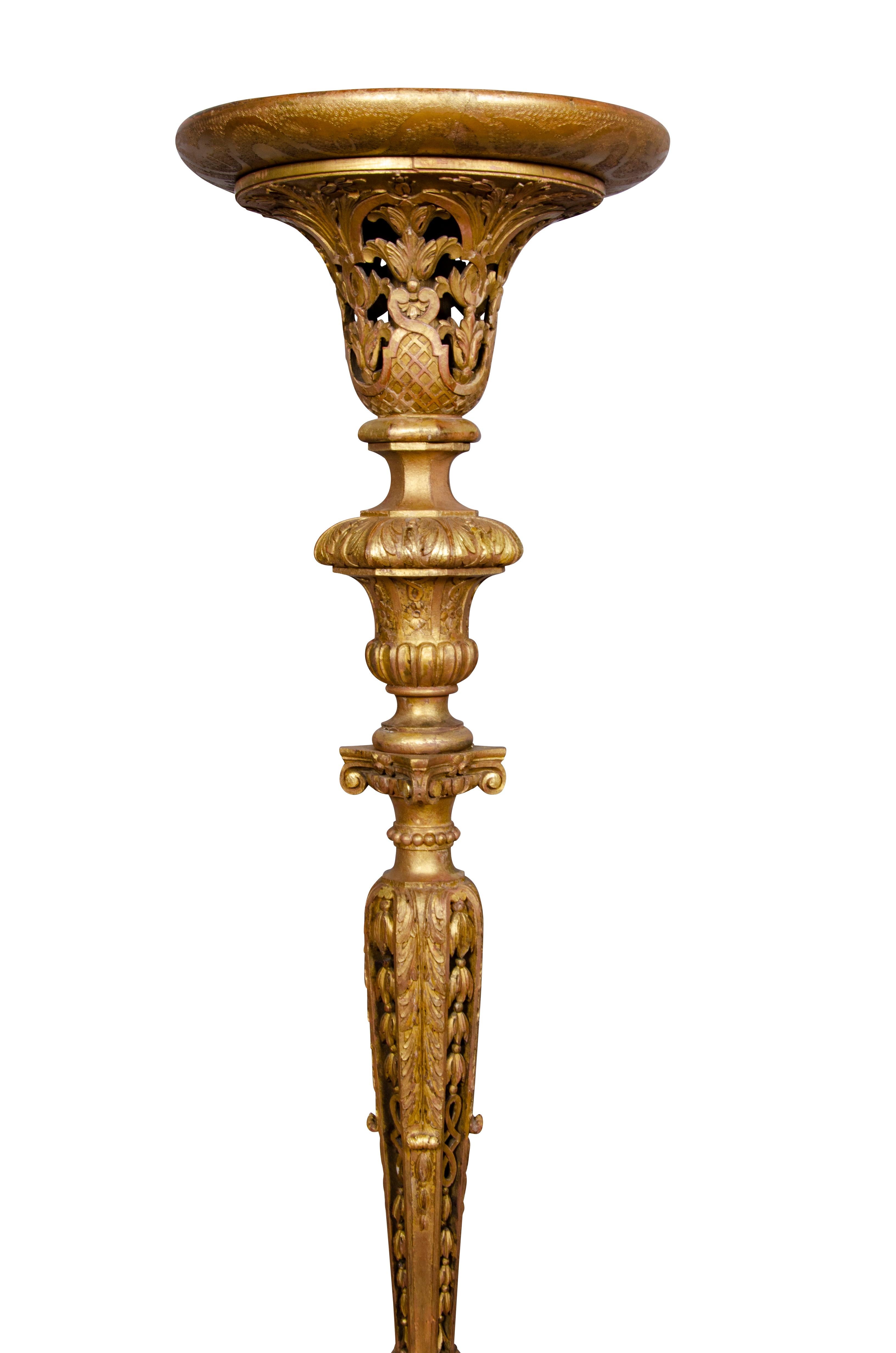 With dished circular tops with a carved and pierced support ending on three carved legs.