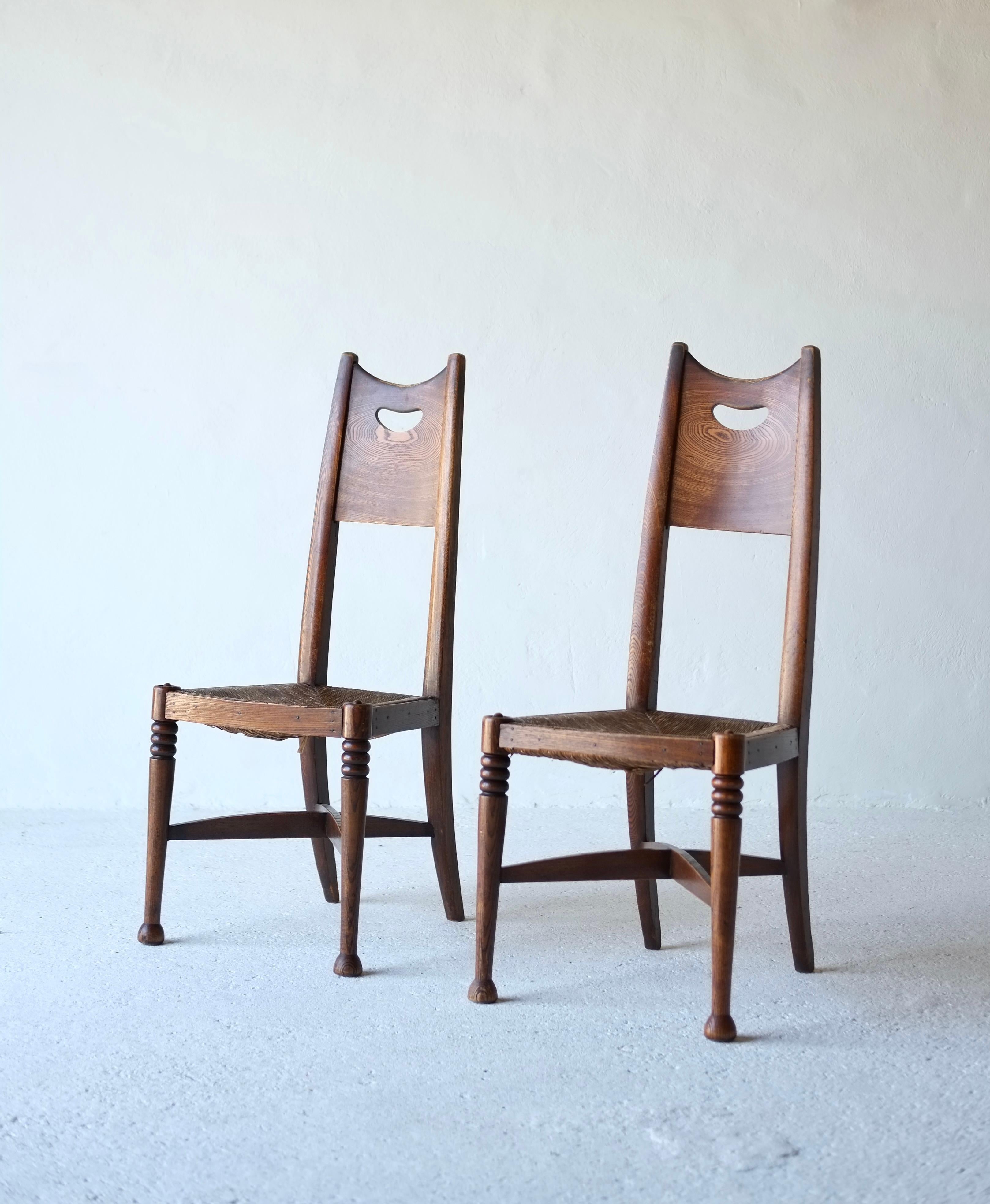 Ein Paar Esszimmerstühle aus Eiche im Arts & Crafts-Stil, hergestellt von William Birch. Das Design wird George Walton zugeschrieben.

CIRCA 1910, England.

Sich verjüngende Rückenlehnen mit durchbrochenen Paneelen über den originalen gepolsterten