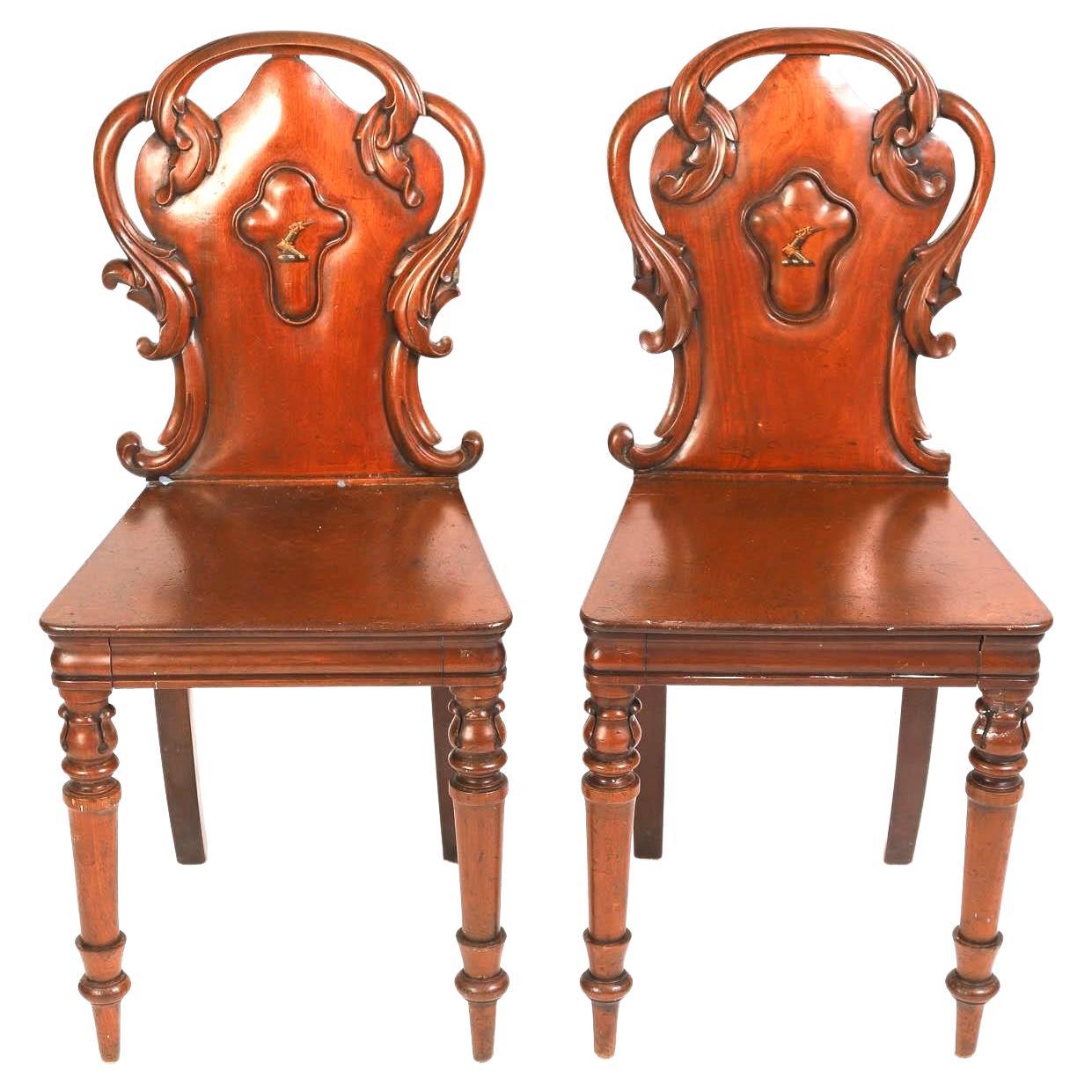 Un par de finísimas sillas de salón de caoba de principios del siglo XIX de Guillermo IV, talladas a mano, con una rica pátina y veteado.  Las sillas presentan un respaldo curvado y con volutas, con una cresta central pintada a mano que muestra una