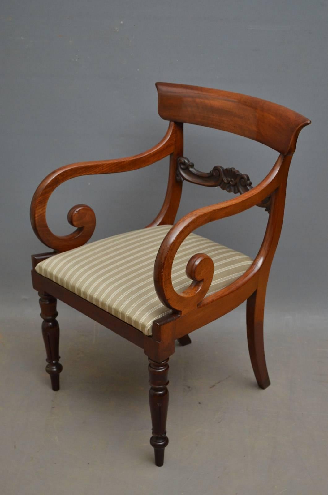 K0320, a pair of William IV mahogany armchairs, each having fantastic figured mahogany top rail with carved mid rail, open scroll arms and upholstered drop in seat, all standing on elegant tulip carved legs. This pair of antique carver chairs is in