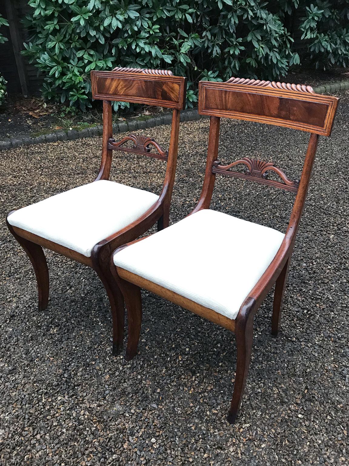 A pair of William IV mahogany bar back dining chairs with reeded decoration and pierced centre rails, with drop-in seats on sabre legs,
circa 1830.

 