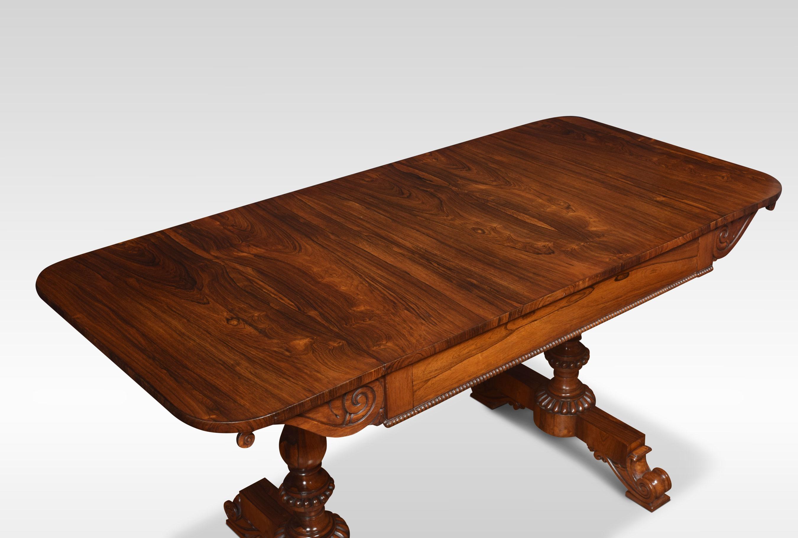 Pair of William IV rosewood sofa tables. The large rectangular well-figured top with rounded corners and lift-up ends. Above the frieze fitted with a large central drawer and a beaded edge. Raised up on turned beaded end supports with rectangular