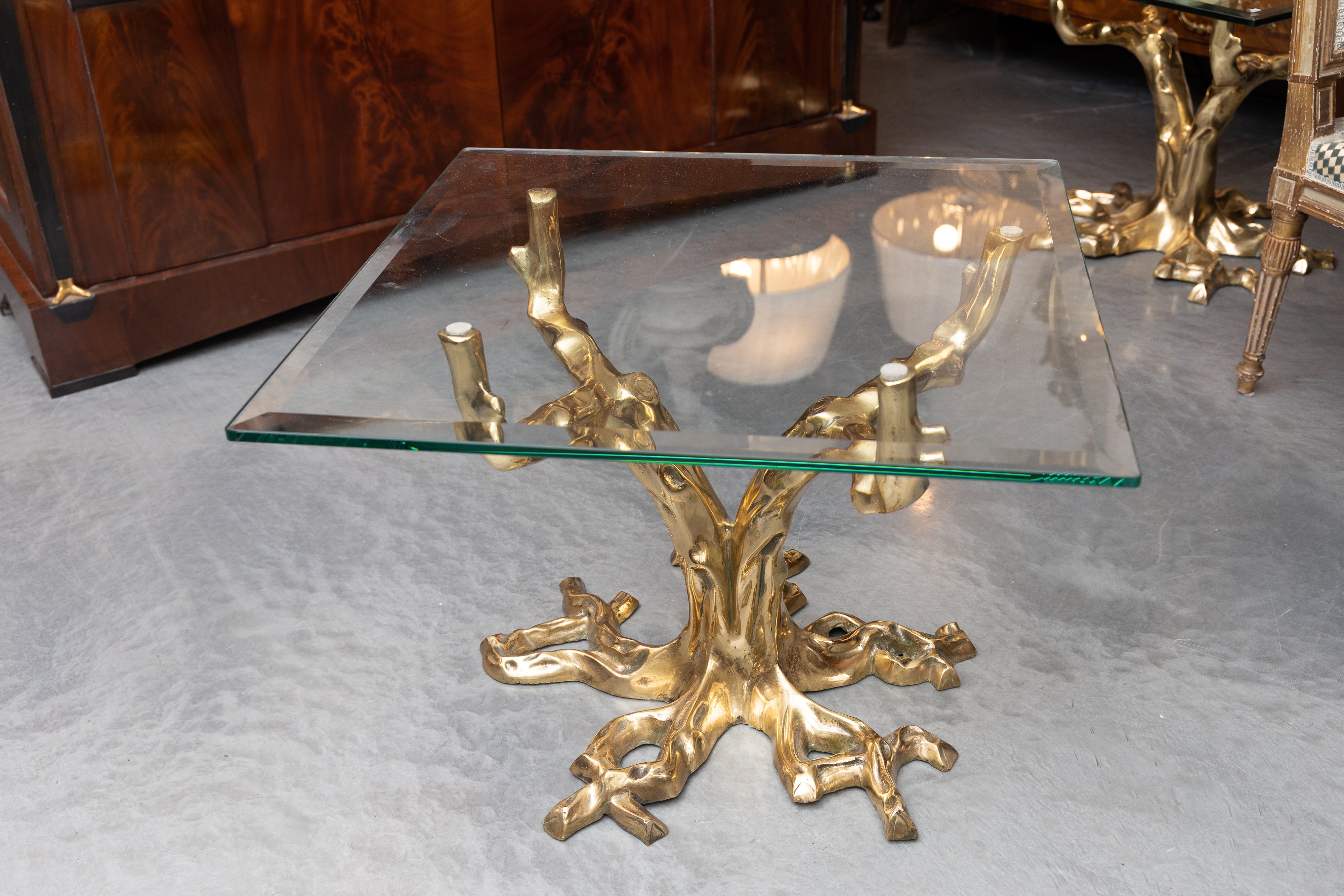 This is an immaculate and sophisticated pair of brass coffee table bases by Willy Daro in the form of a tree supporting a glass top and presenting a meandering root system at the base, circa 1970.