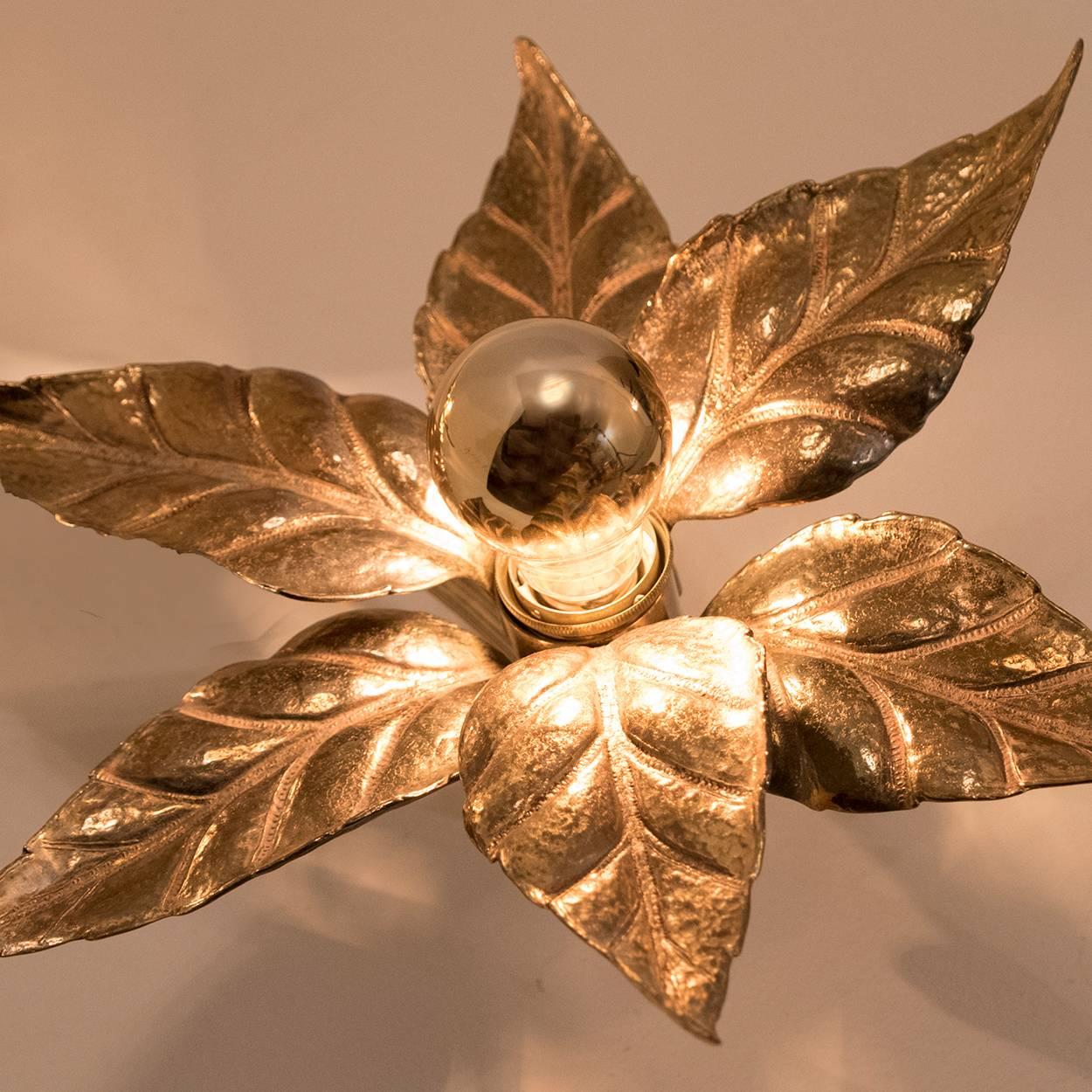 Nice pair of brass flowers wall lights in the style of designer Willy Daro manufactured by 'Massive Lighting', circa 1970s, Belgian. This decorative and beautiful large sculptural light consists of a pair of brass plated flowers on a bar and