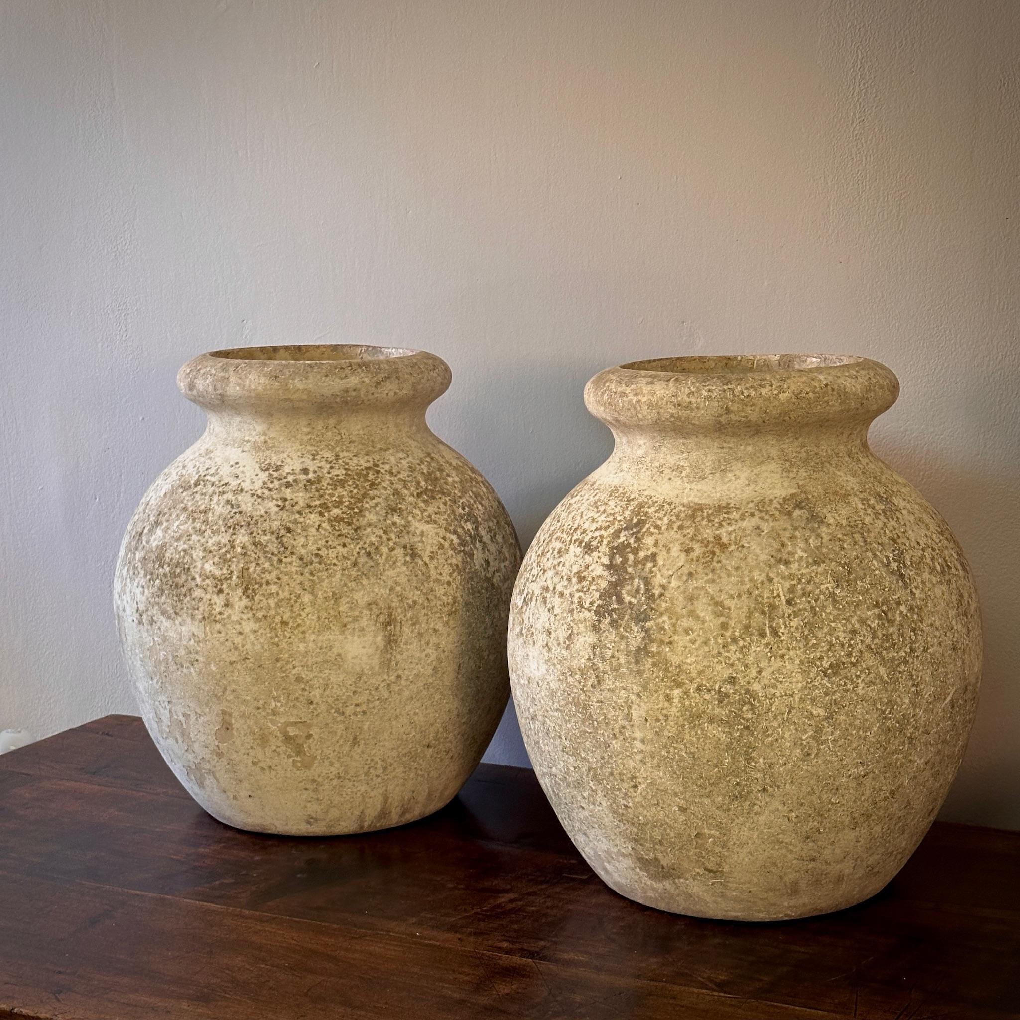 Cette paire de pots en béton du milieu du siècle, conçue par le célèbre designer suisse Willy Guhl, incarne une synthèse saisissante de l'esthétique brutaliste et de la patine naturelle. Ces récipients ronds et robustes sont suffisamment polyvalents