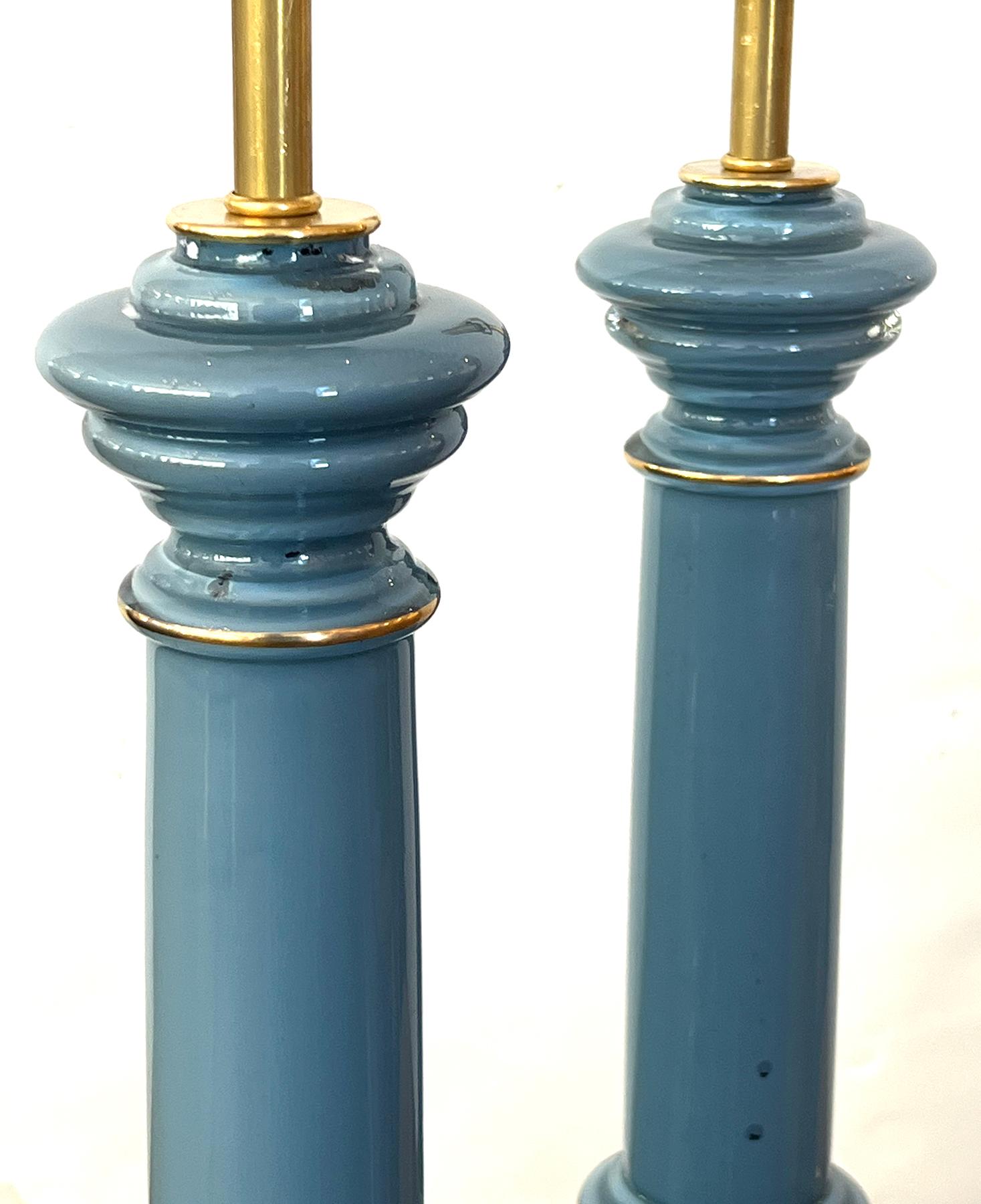 each lamp of columnar form with long cylindrical neck over a stepped base all resting on a brass foot; 18.5