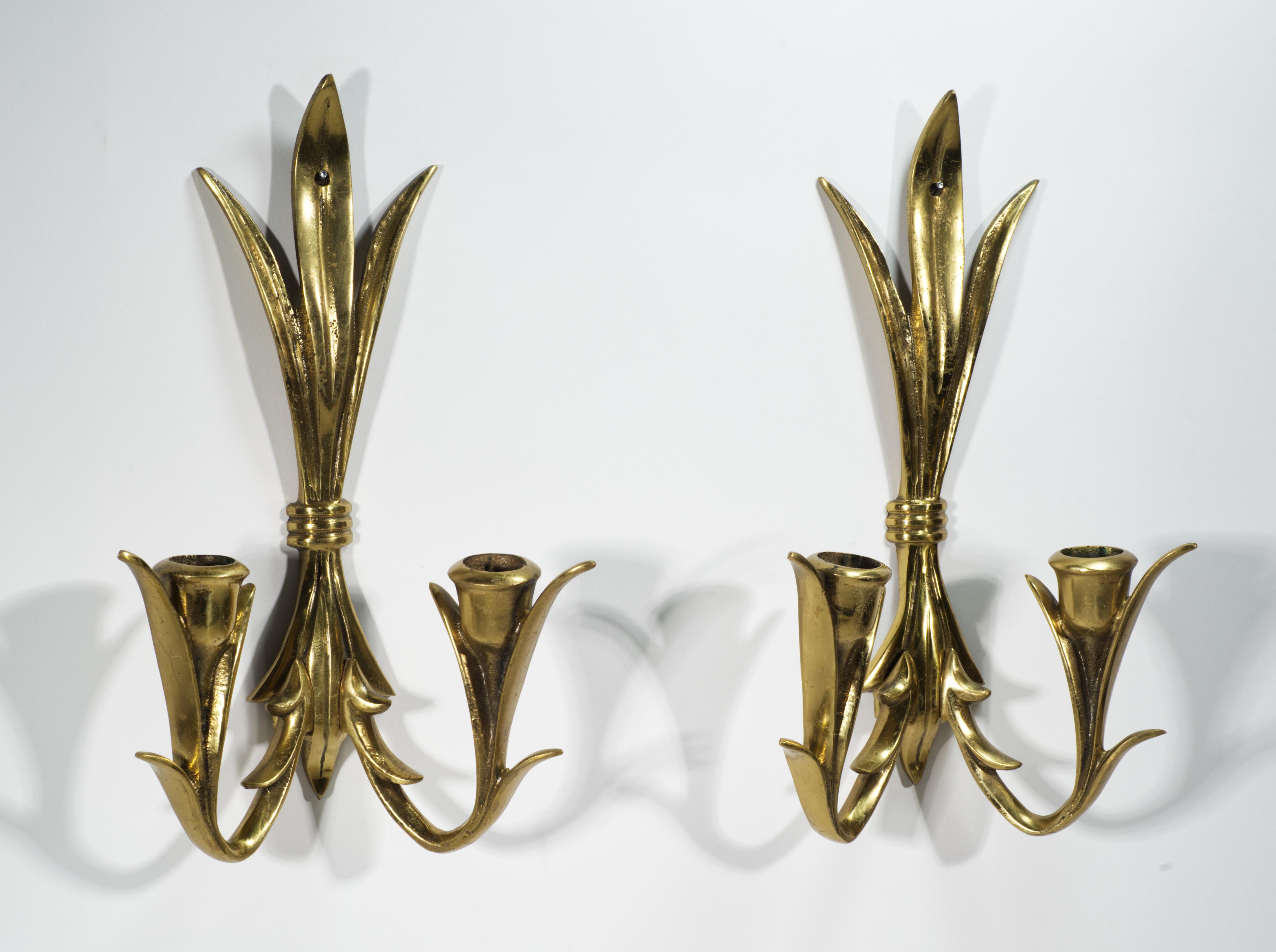  Pair of striking Wilton brass wall mounted candle stick holders or sconces has highly detailed, ornamental design. The candle holders support two candles per piece; they are signed on the back. The sconces are in good vintage condition with