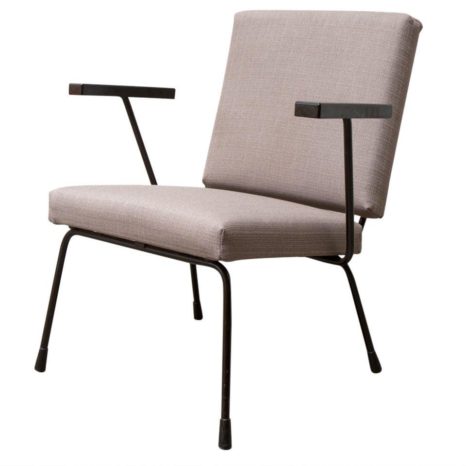 Including two similar Wim Rietveld Model 1401 Lounge Chairs chairs in differing upholstery. 

The first is black enameled steel frame with Bakelite armrests and new dense foam and newly upholstered with midnight navy fabric. Frame in original