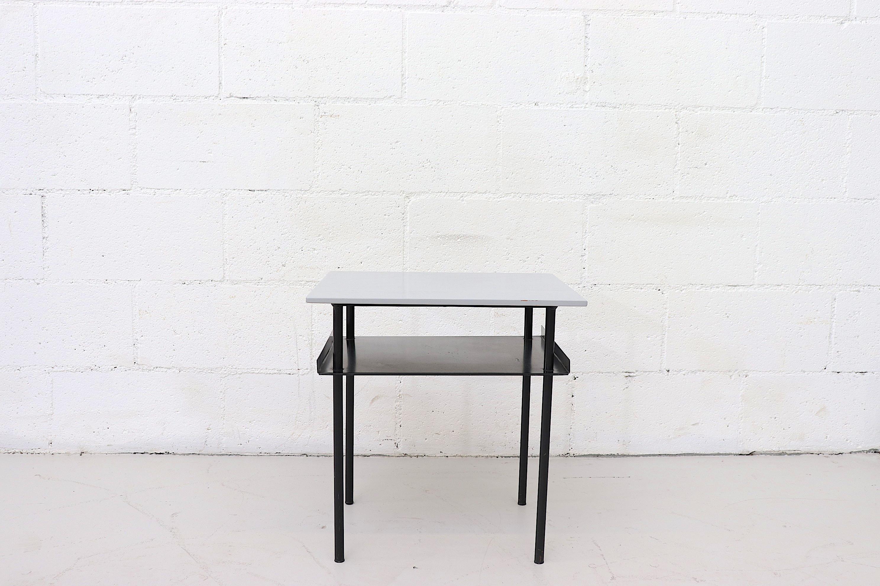 Small pair of midcentury Wim Rietveld style side tables by auping with painted grey plywood top and enameled black metal legs with sheet metal lower shelf. Frames in original condition. Both tops and frames show wear, consistent with their age and