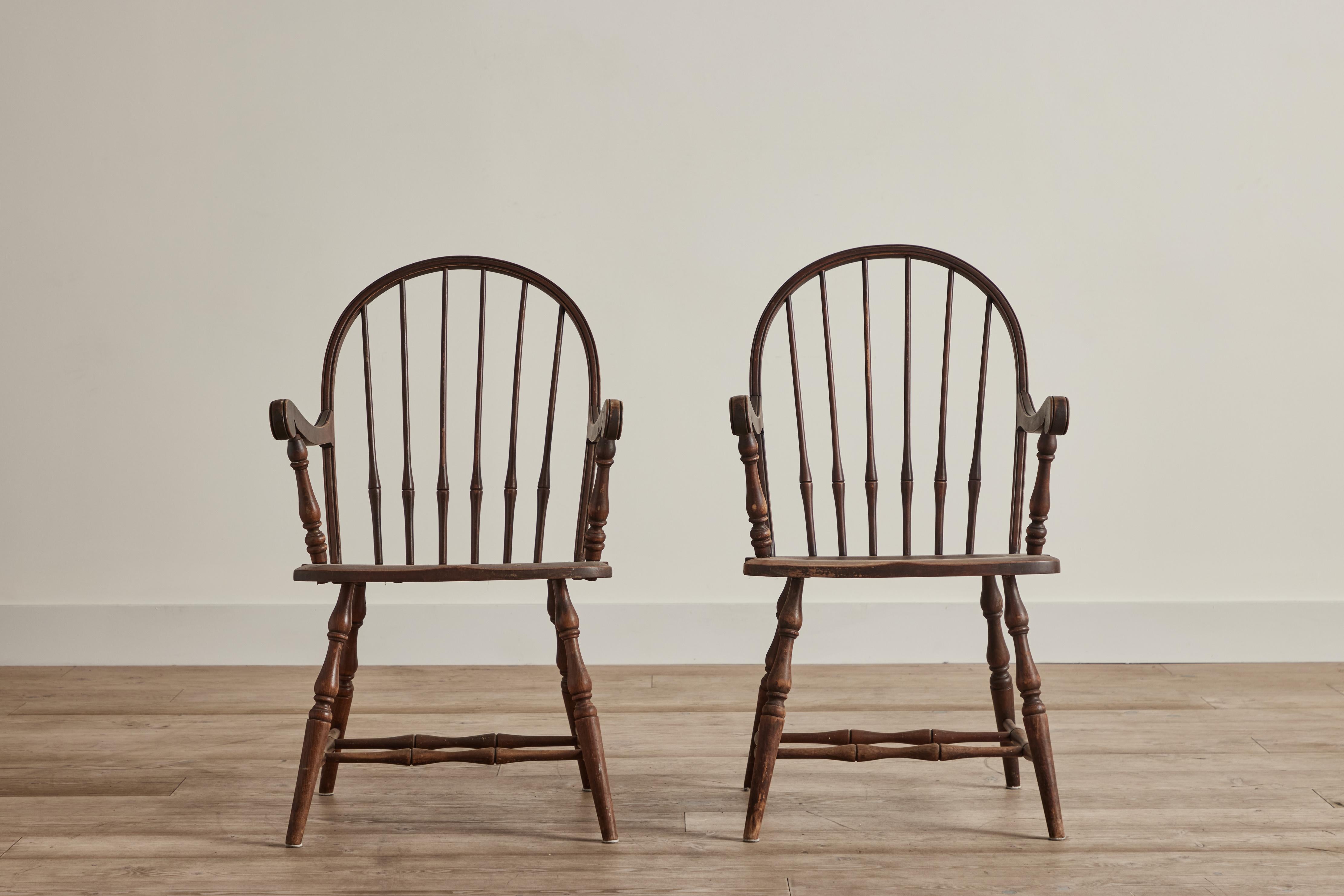 Pair of Early American painted wood windsor chairs. Wear throughout that is consistent with age and use. 