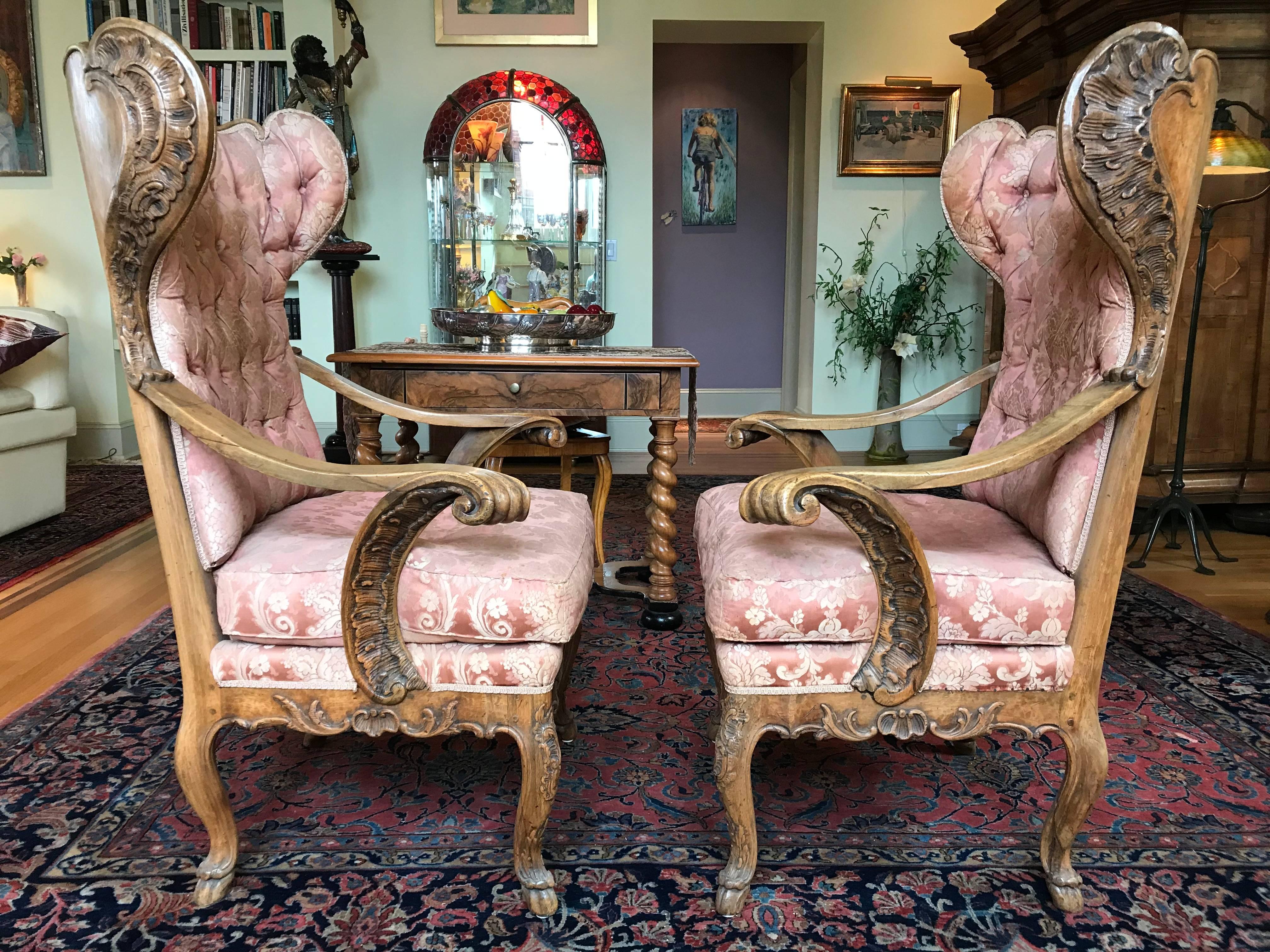 A gorgeous pair of hand-carved walnut wing chairs in the baroque style, German, circa 1860.