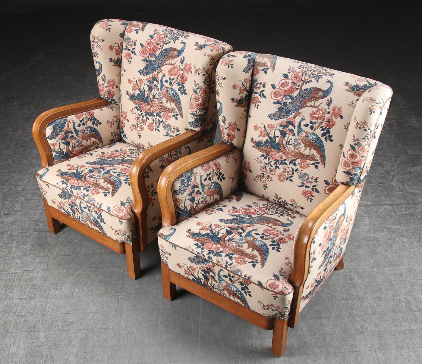 Pair of Danish modern wingback armchairs with oak frame, upholstered in floral upholstery, mid-20th century with curved, polished oak arms, circa 1940s, solidly built.