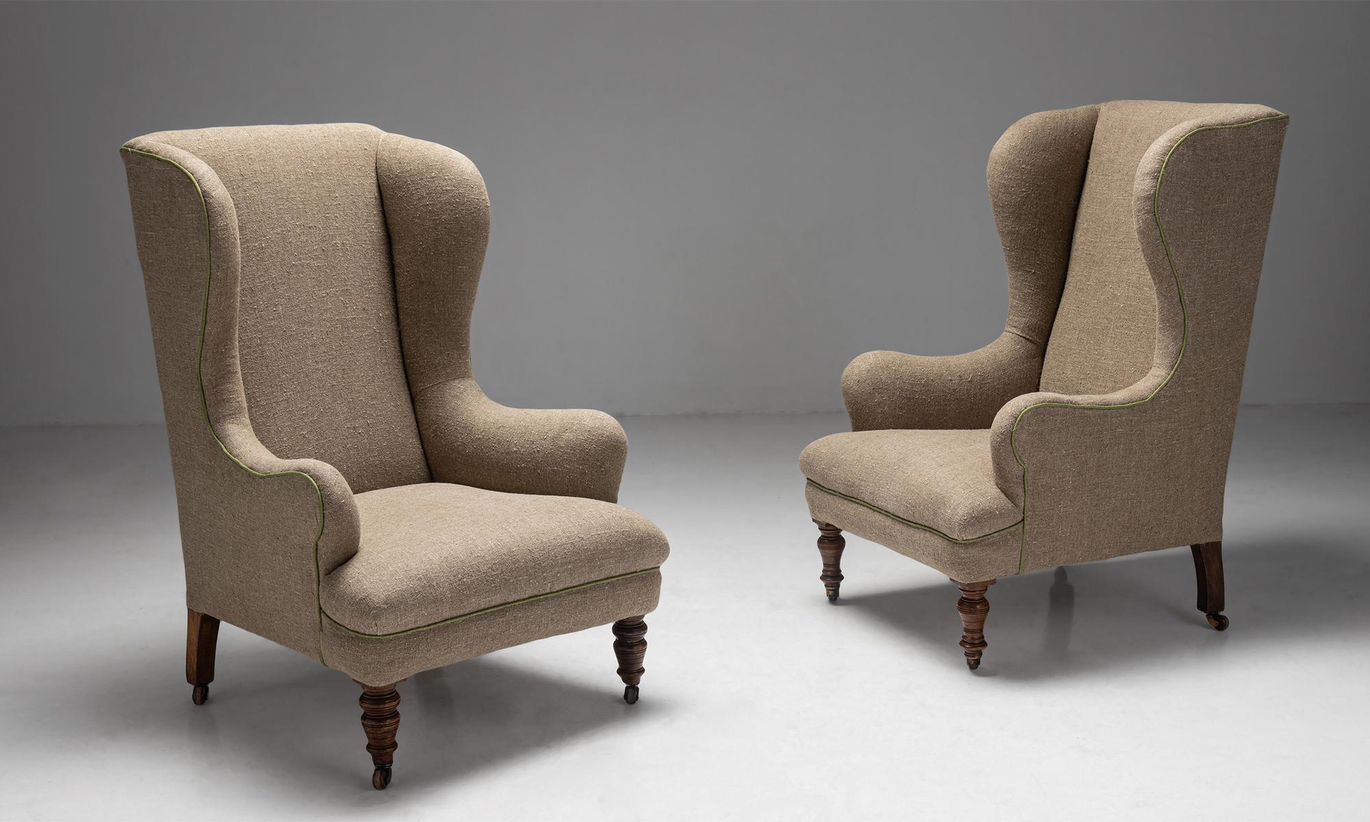 Wingback armchairs, Spain Circa 1890.

Newly upholstered in stone washed linen with contrast piping, on turned mahogany legs with original castors.
