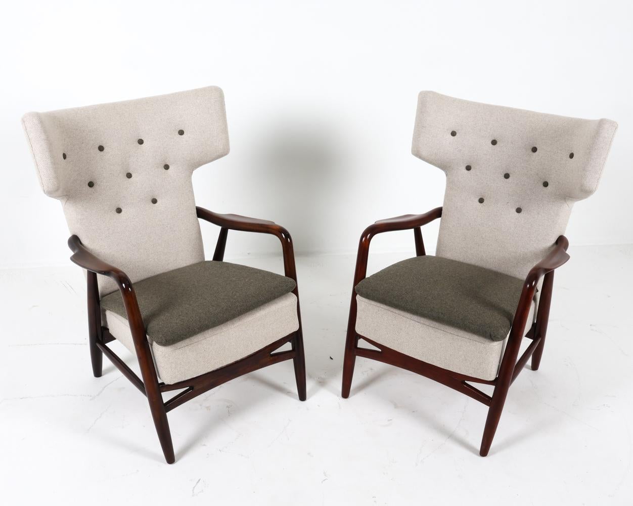 This is an important and exceptionally rare pair of wingback armchairs designed by Eva Koppel in 1947. The pair was manufactured by Slagelse Møbelværk in Denmark. The frames of these chairs are crafted from dark stained beech wood and upholstered in