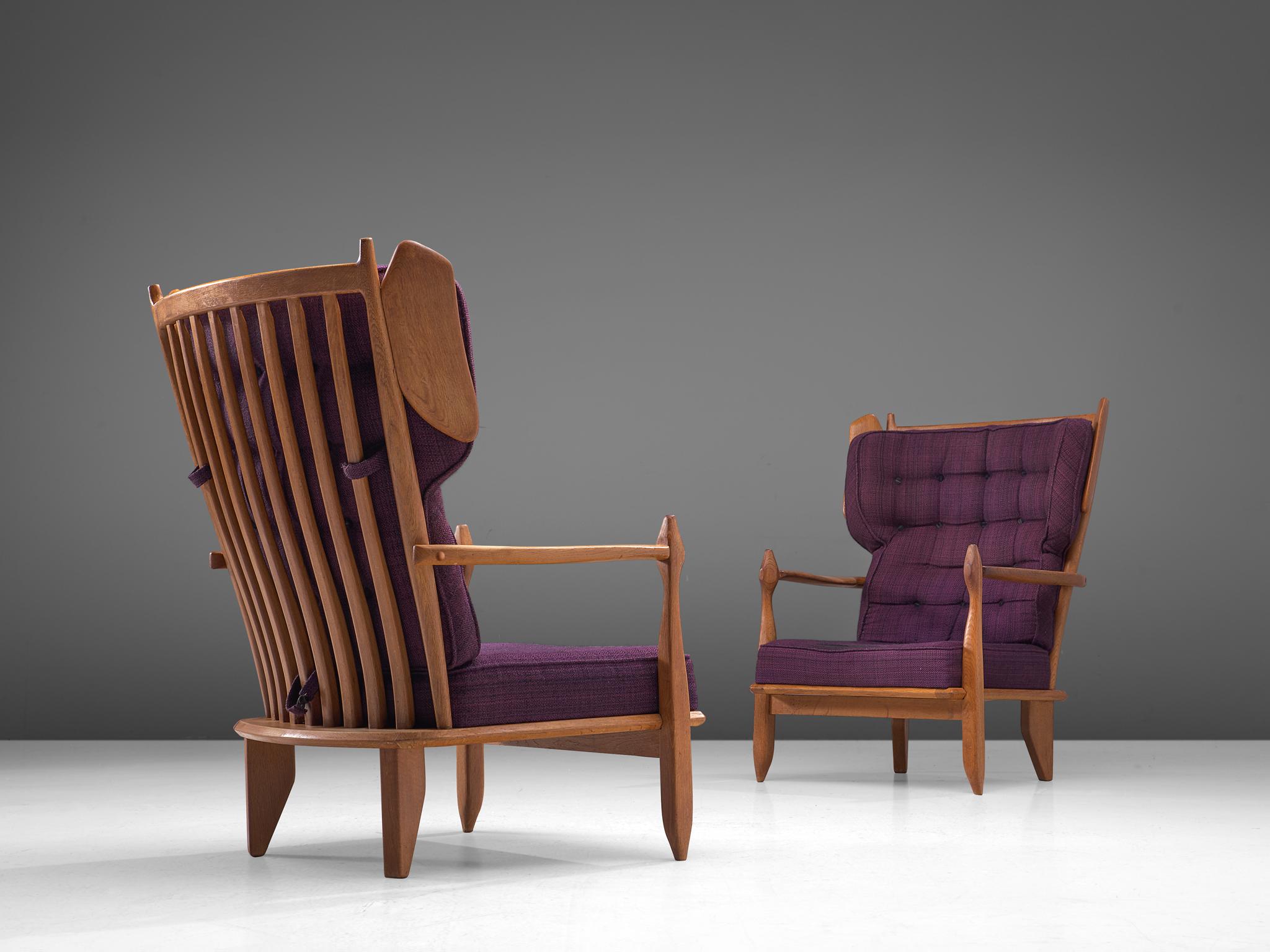 Guillerme et Chambron, pair of lounge chairs, oak and fabric, France, 1960s.

Guillerme and Chambron are known for their high quality solid oak furniture, from which these are a great example. These high back chairs with wings have an interesting,
