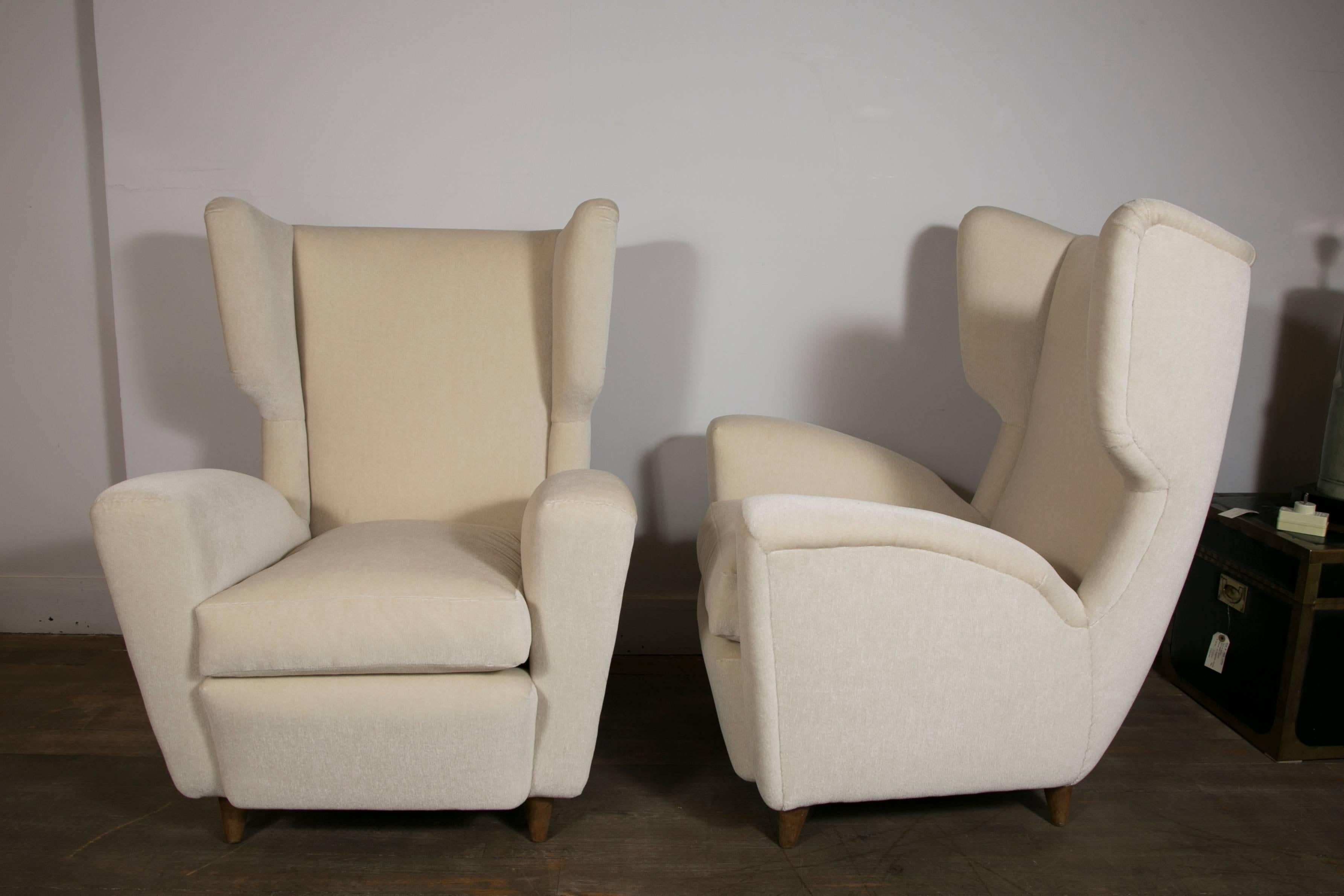 A pair of wingback lounge chairs
Newly re upholstered with ivory mohair velvet (Nobilis).
Elegant chairs in the style of Gio Ponti or Paolo Buffa
Italy, 1950s.