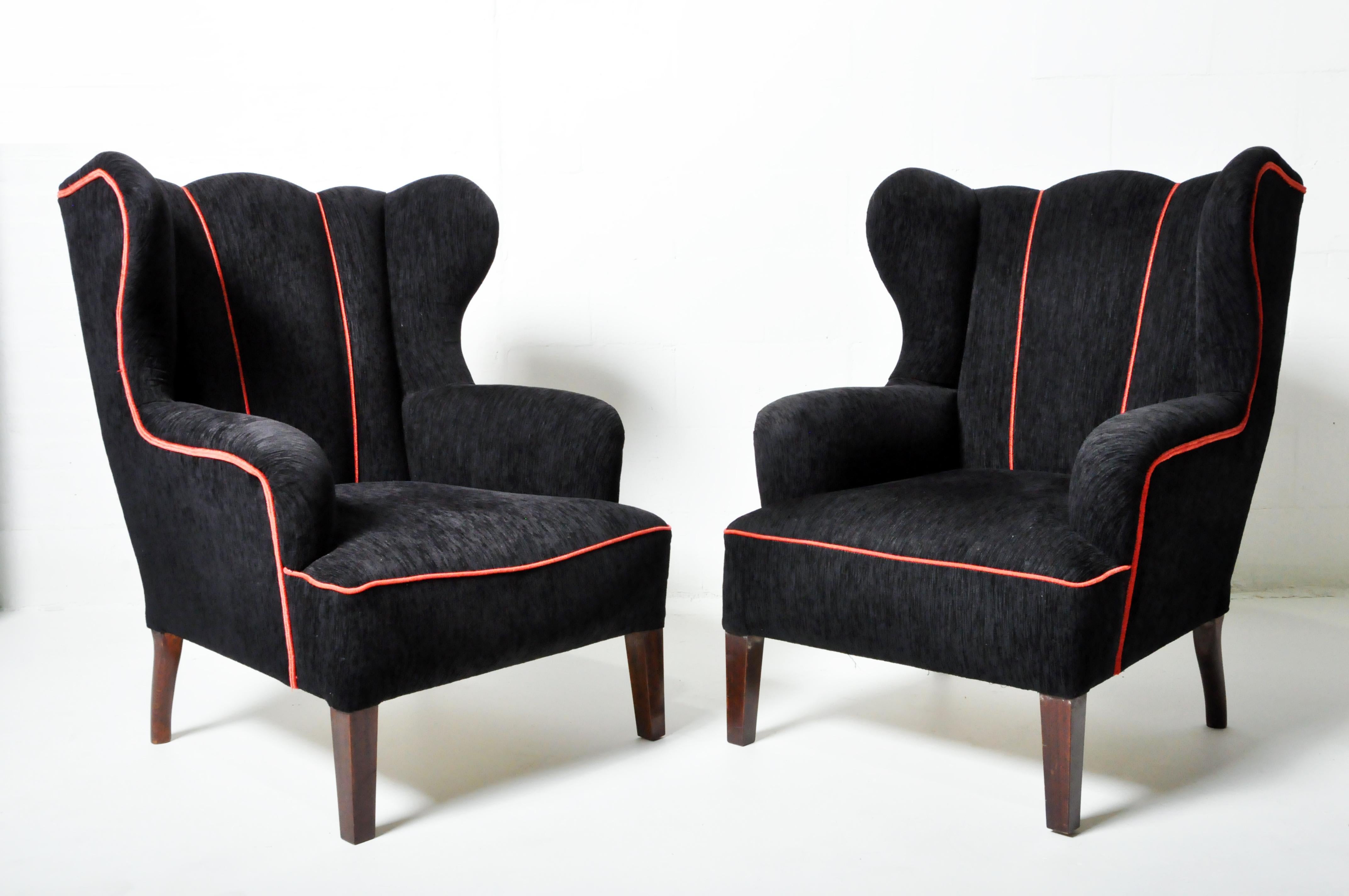 This pair of wingback chairs is a 1950's Hungarian interpretation of the classic form. Wingbacks were originally created to block the air in drafty rooms. These chairs are modernized and streamlined but still cozy and comfortable. Upholstered in