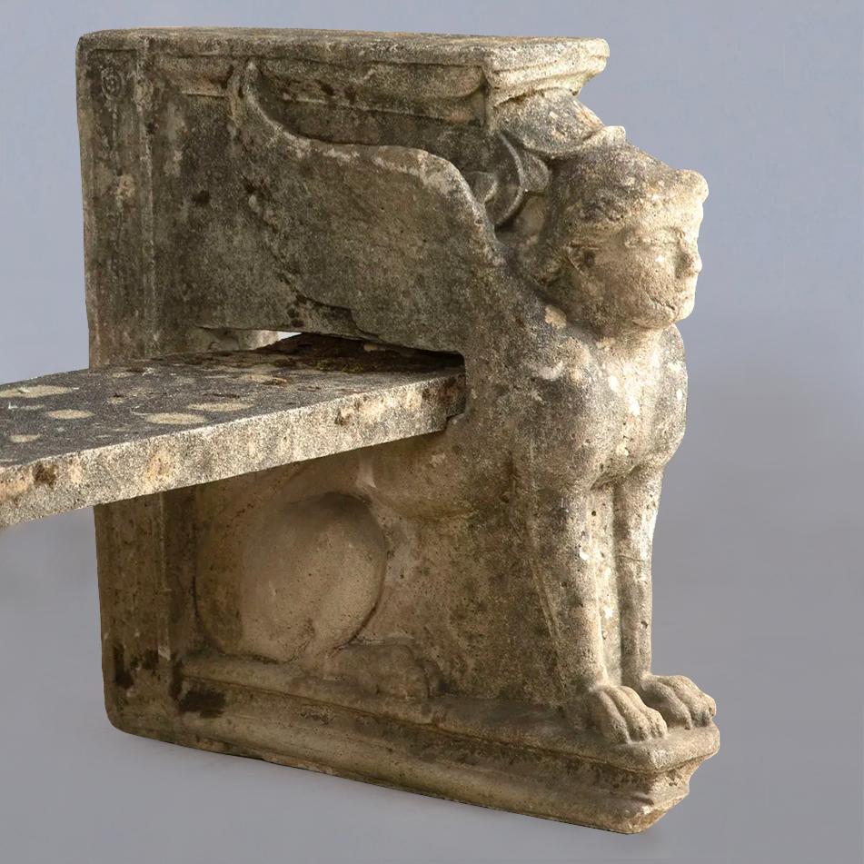 Pair of elegant yet substantial beautifully weathered reconstituted stone benches with male winged sphinx ends. The seat could easily be reduced in length as each bench dismantles into three separate stone pieces. Can be sold individually.