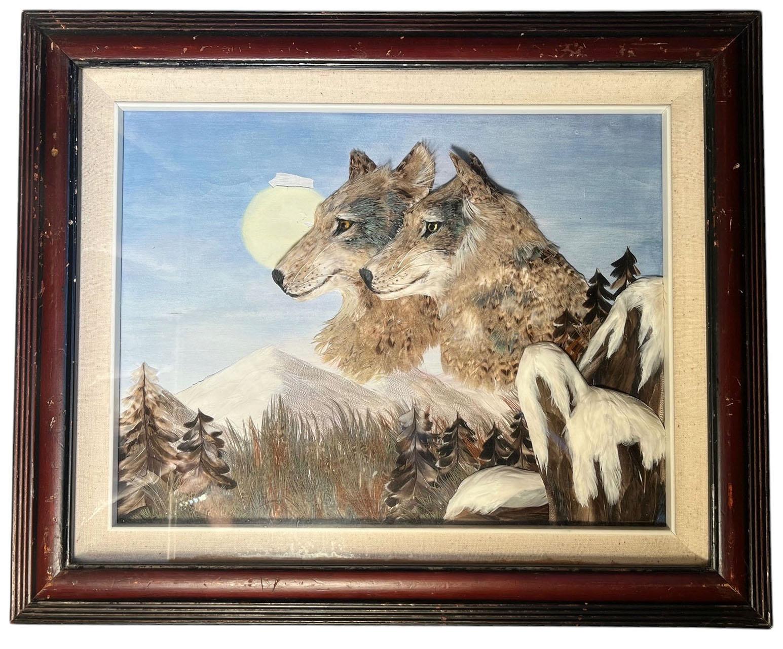 Un cuadro de época de dos lobos, una luna y montañas hecho totalmente de plumas en una caja de sombras que muestra sujetos tridimensionales.  Algunas pérdidas de pintura cerca de la luna, por lo demás en perfecto estado. La obra mide diecisiete por