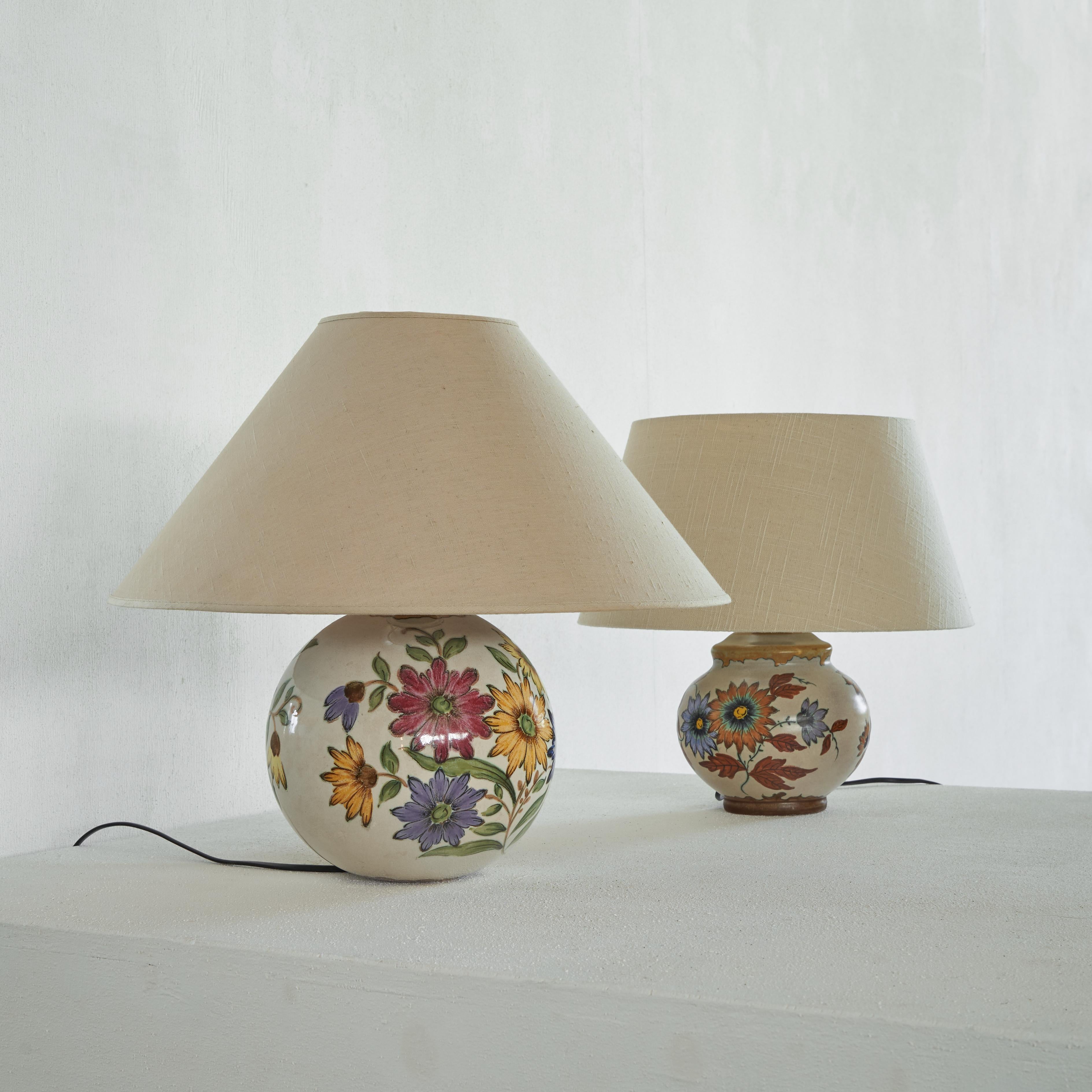 Pair of wonderful Dutch ceramic table lamps with a hand painted floral decor. The Netherlands, 1930s.

Very stylish and elegant pair of table lamps with a floral decor. The completely round one has a colorful summer feel and the slightly smaller and