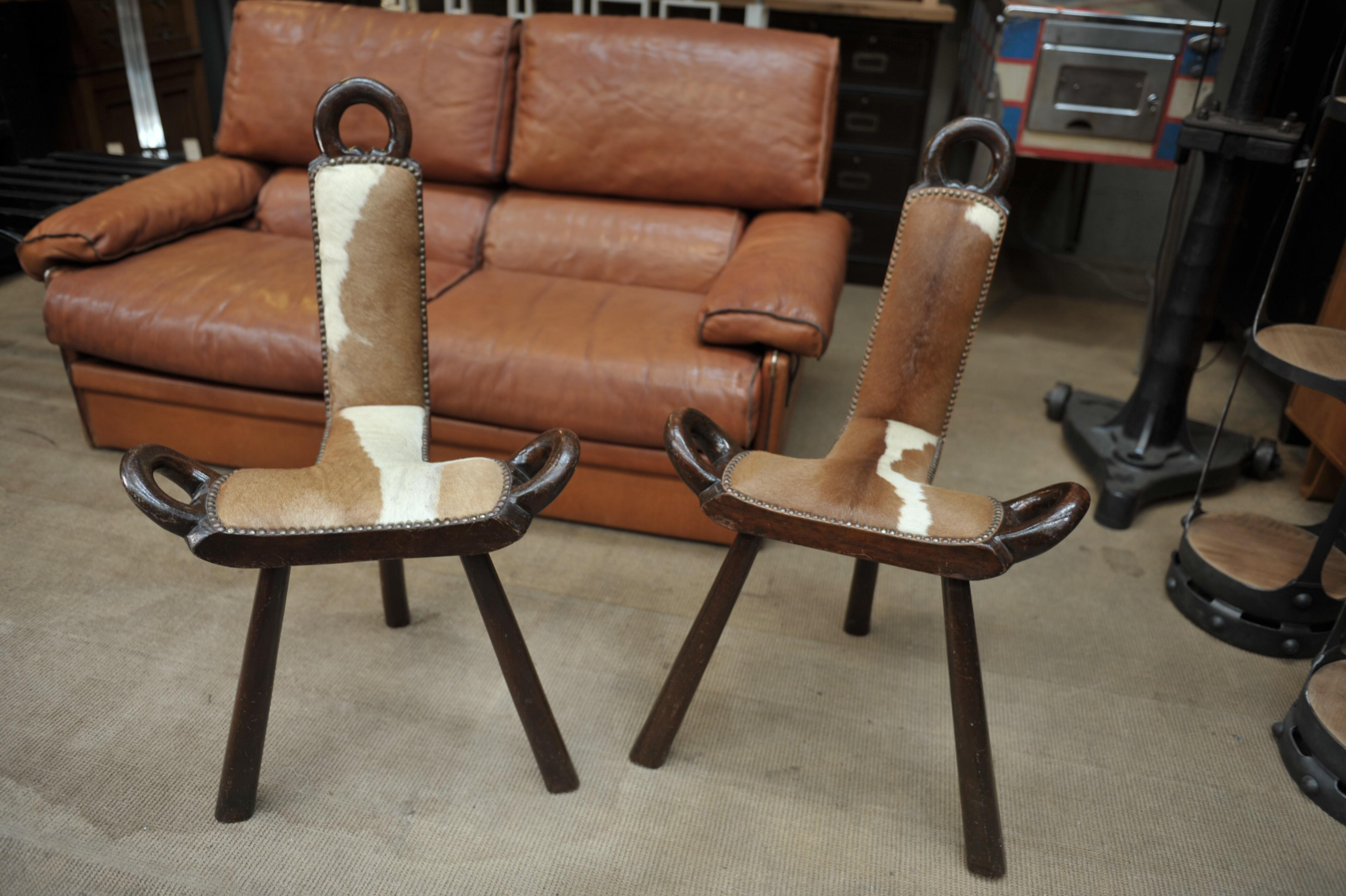 Pair of wood and cow skin chairs, France, circa 1960.
