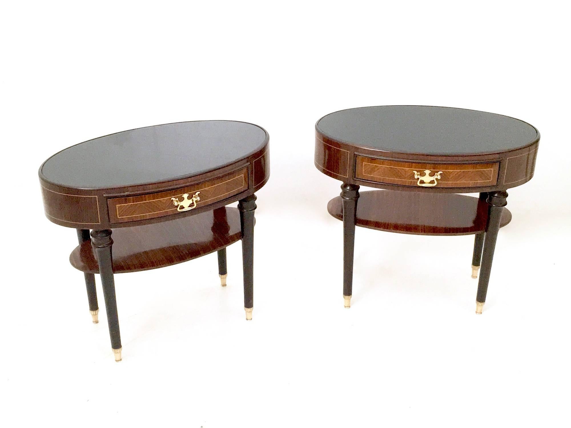 Made in wood and ebonized wood.
They feature a back-painted glass top and brass feet caps and handles.
In excellent original condition and ready to become a piece in a home.

Measures: Width 57.5 cm
Depth 34 cm 
Height 51 cm.