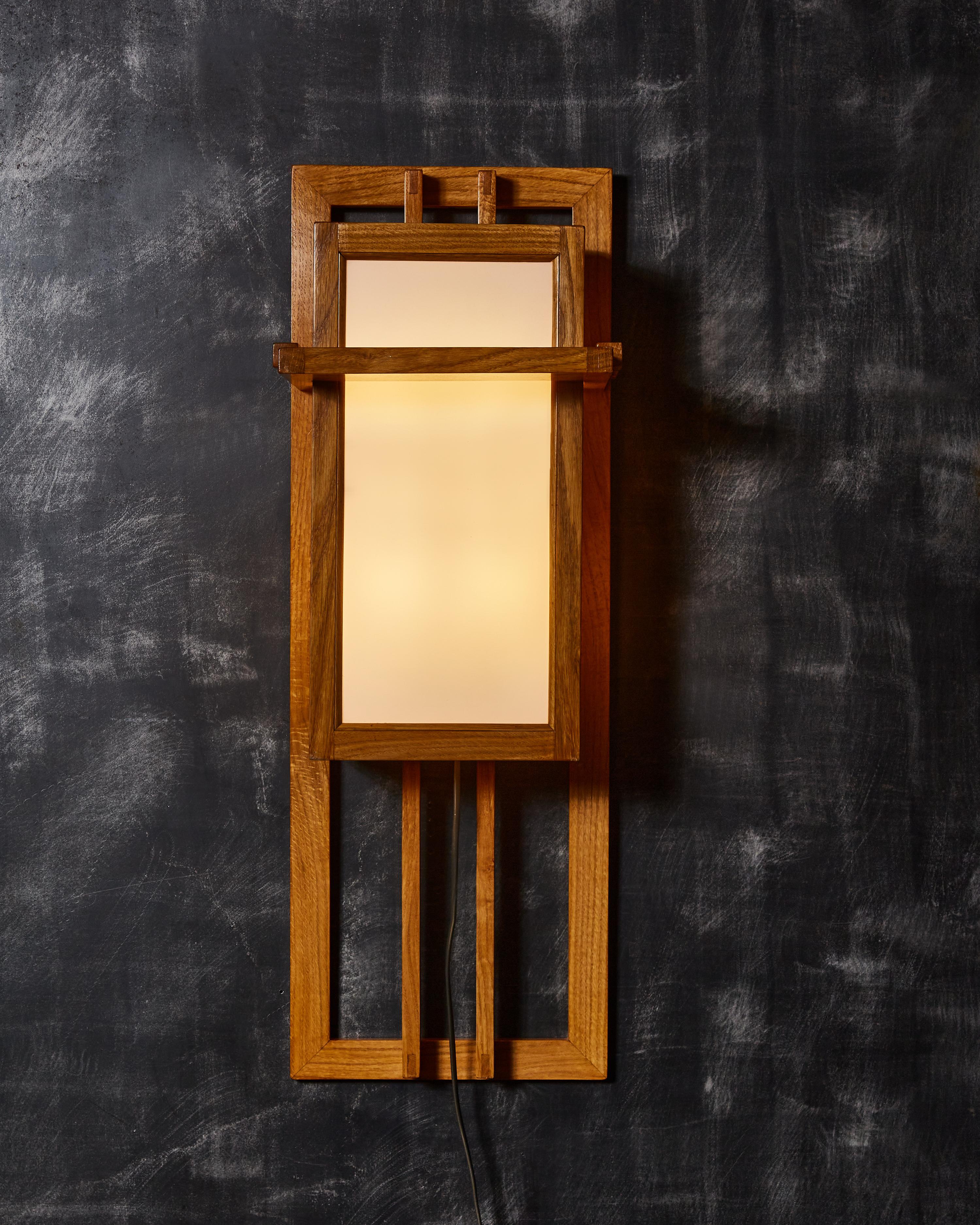 Pair of wall sconces made of a geometrical wood structure and white frosted glass panels. Four lights per sconce.