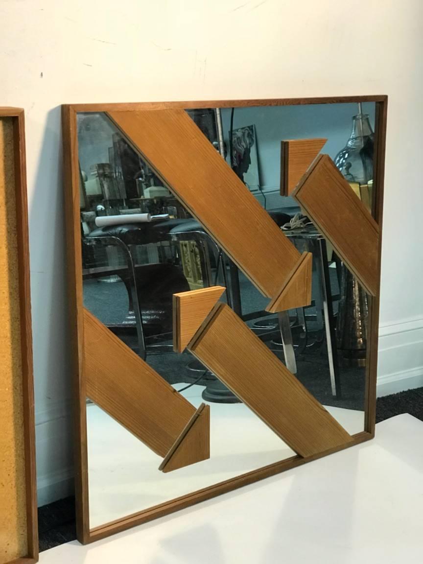 1970s three dimensional pair of modern wood arrow design mounted on mirror wall mirrors. This pair of mirrors are the same width and height except one is 2